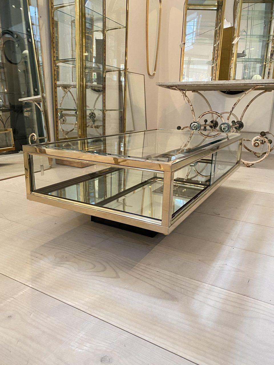 Elegant and stylish French coffee table / coffee table. Created the legendary interior house Maison Jansen circa 1970s. Beautifully made with glass and sleek and simple brass profiles, as well as a black-painted wooden base.

Maison Jansen was one