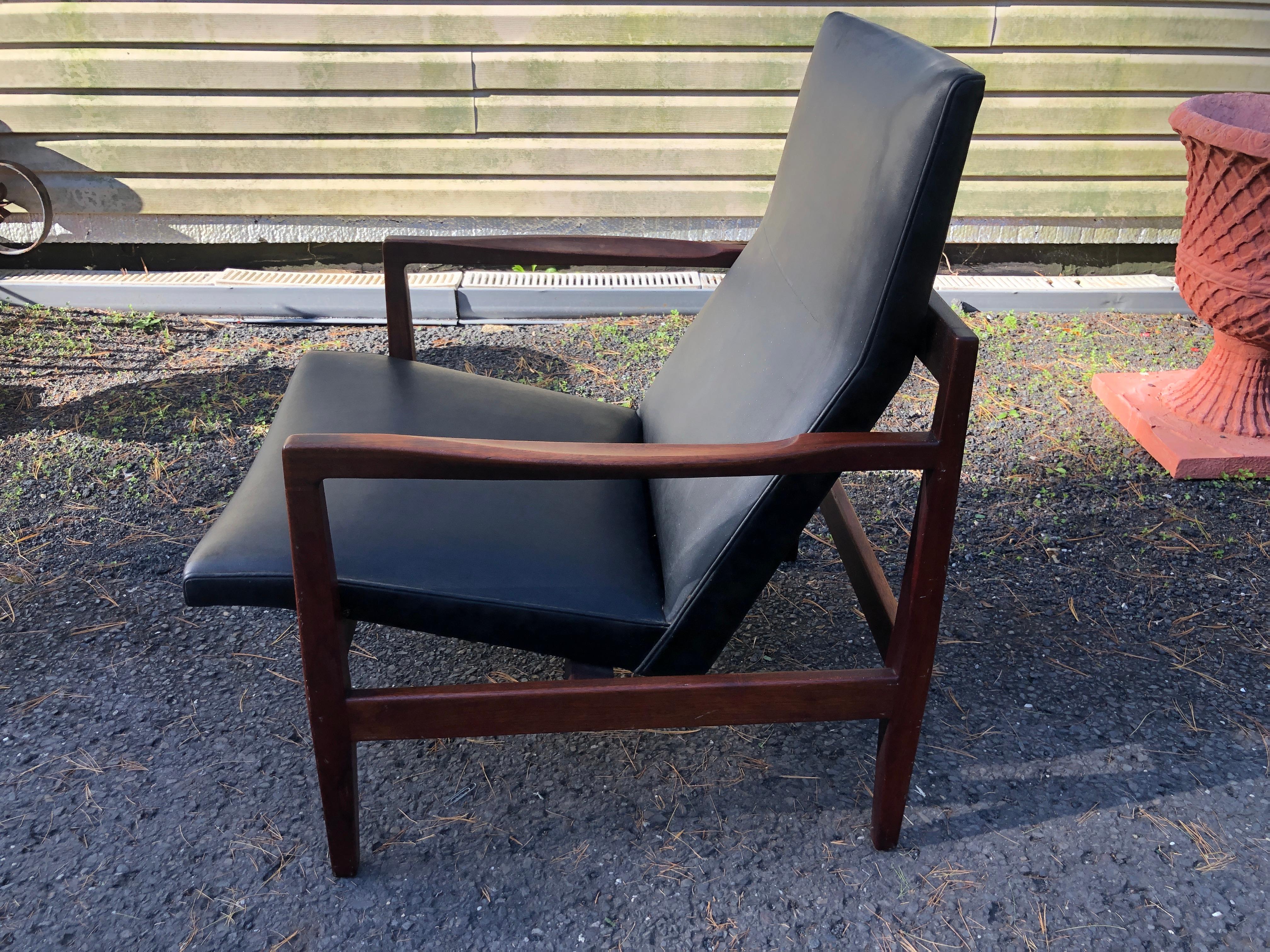  Conçue par le Danois Jens Risom, cette chaise vintage est une belle perfection. Le siège en similicuir aux contours confortables flotte dans un cadre exquis en noyer huilé. Le numéro de modèle original est U440.   Jens Risom (1916-2016) a été l'un