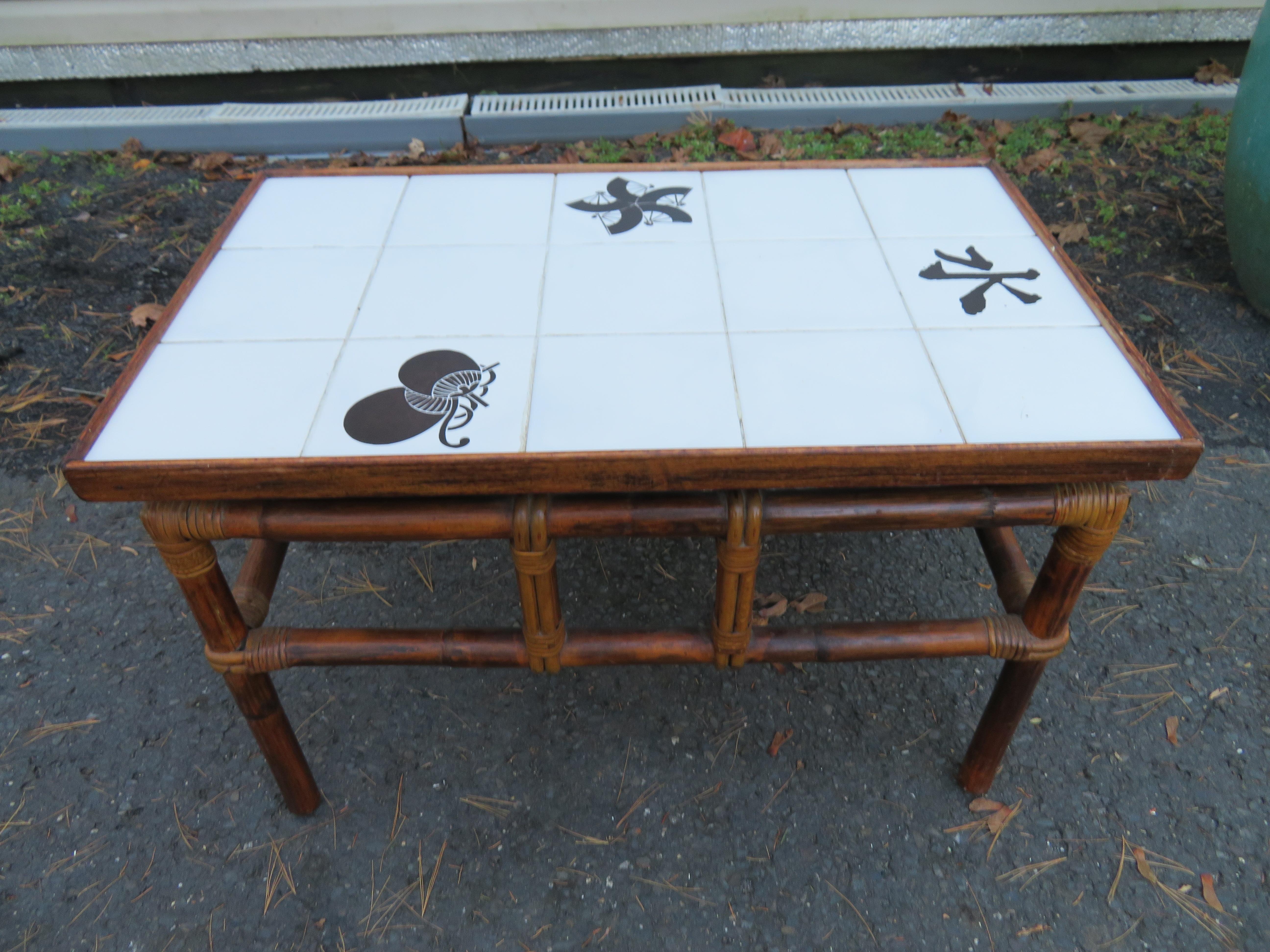 Handsome John Wisner for Ficks Reed Asian modern tile top side table. This piece features a white tile top framed with solid mahogany with applied Chinese character and fan decoration. The table is supported by a simple and classic stained bamboo