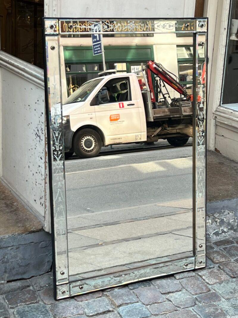 Gorgeous old Venetian mirror from France, around 1920 – 1940, with fantastic patina in the mirrored glass.

From the era, where the faceted ornaments, would elegantly reflect the light.

Beautiful floral ornamentation in the frame along the