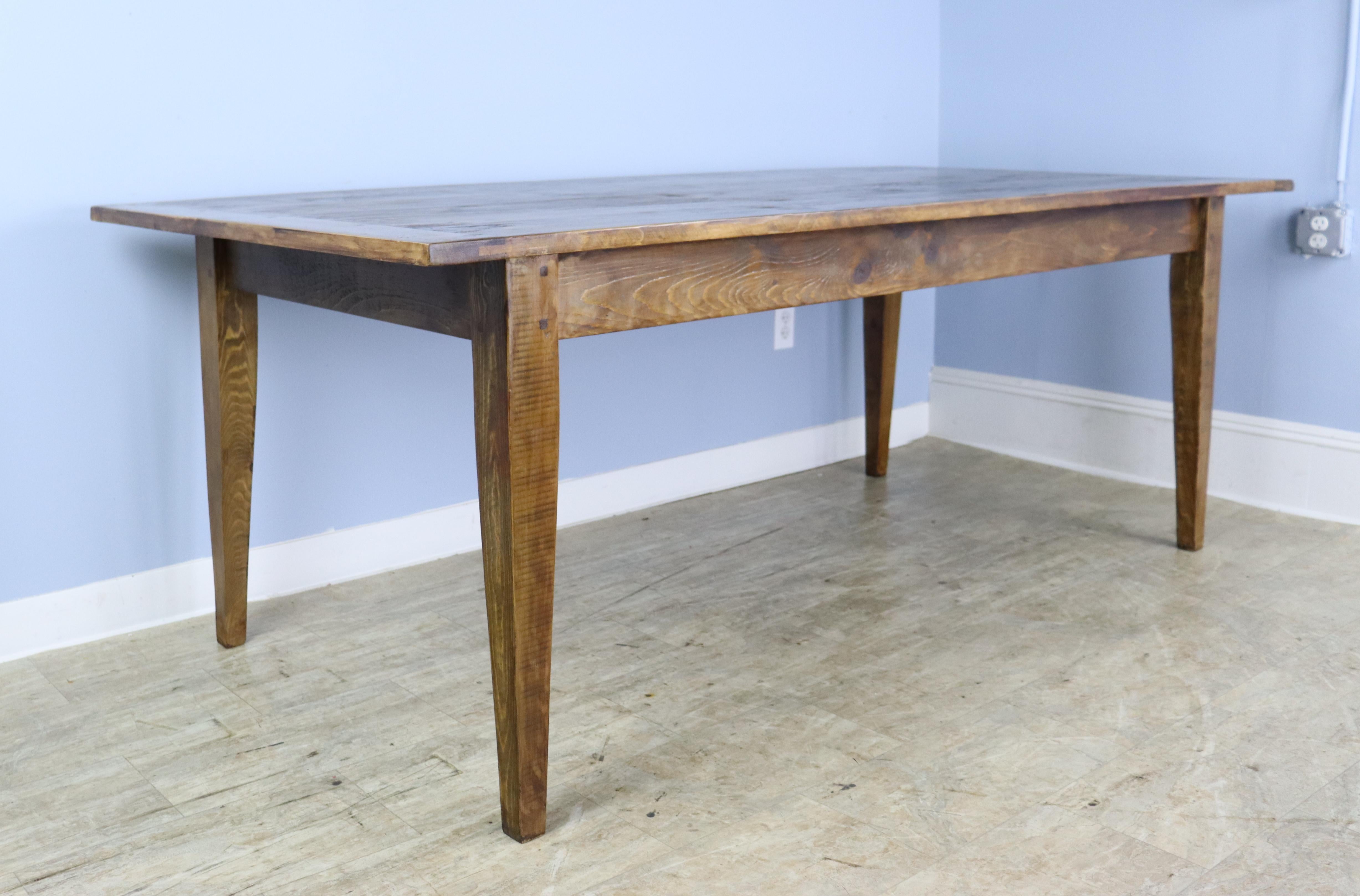 A generously proportioned, thick topped farm table in medium pine 7'. Great depth to the top. With 68 inches between the legs, this table can easily fit eight with room for a Thanksgiving dinner as well! The apron height of 25 inches is good for
