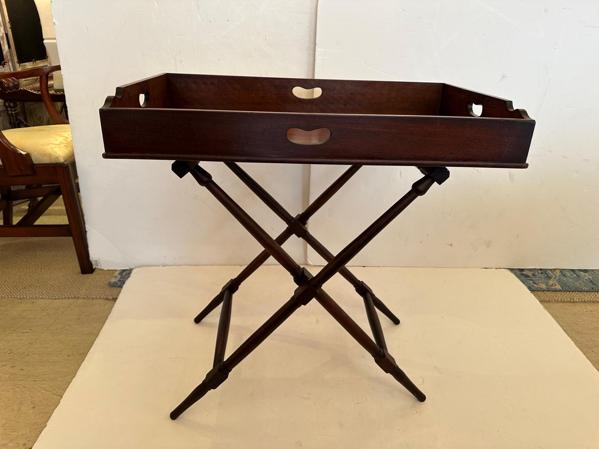 Handsome mahogany butlers tray on folding stand; stand has needlepointed straps with medallions as the cross supports.