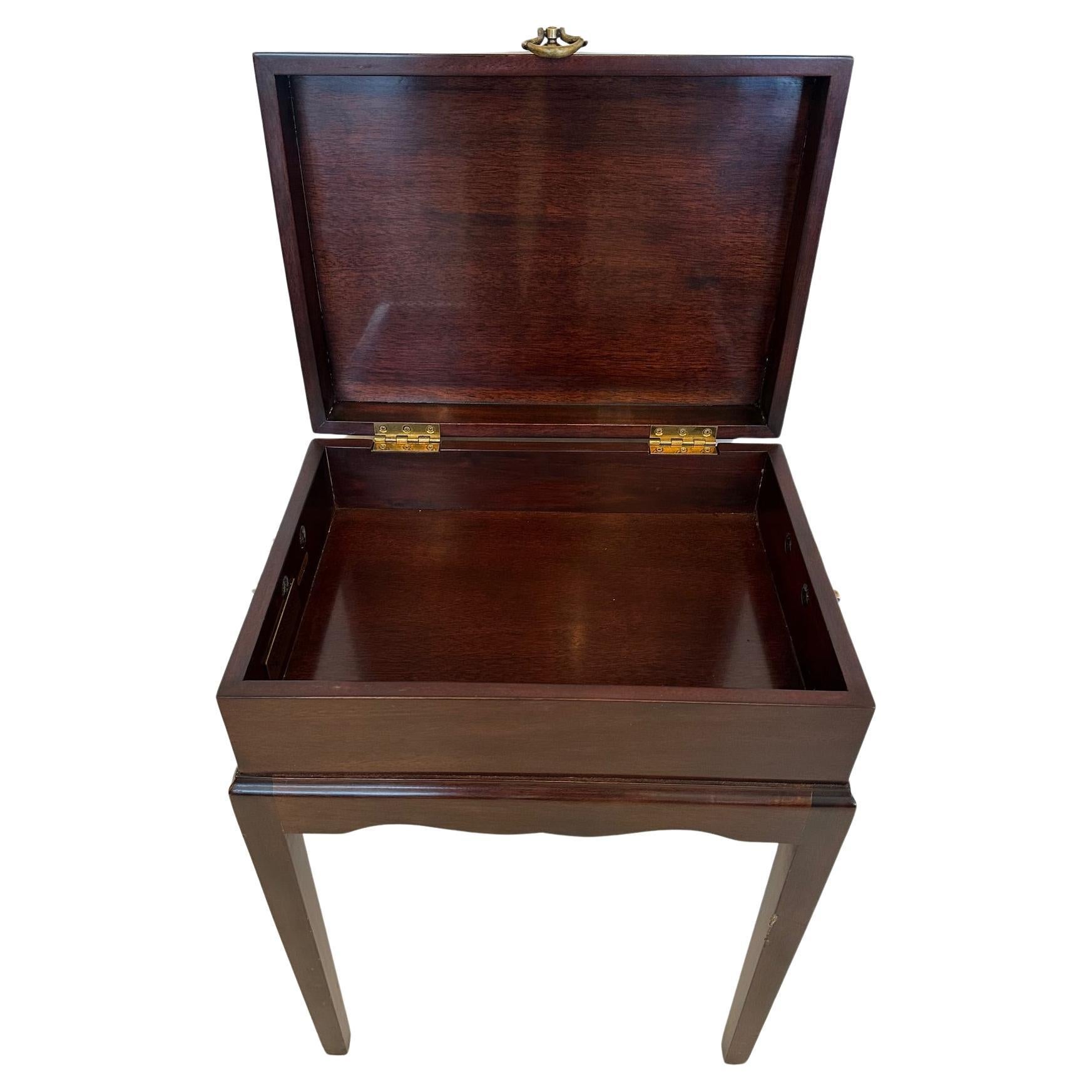 Handsome mahogany box on stand having inlaid decorative nautilus shell on tops and brass handles.  Makes a nifty end table with storage inside. 