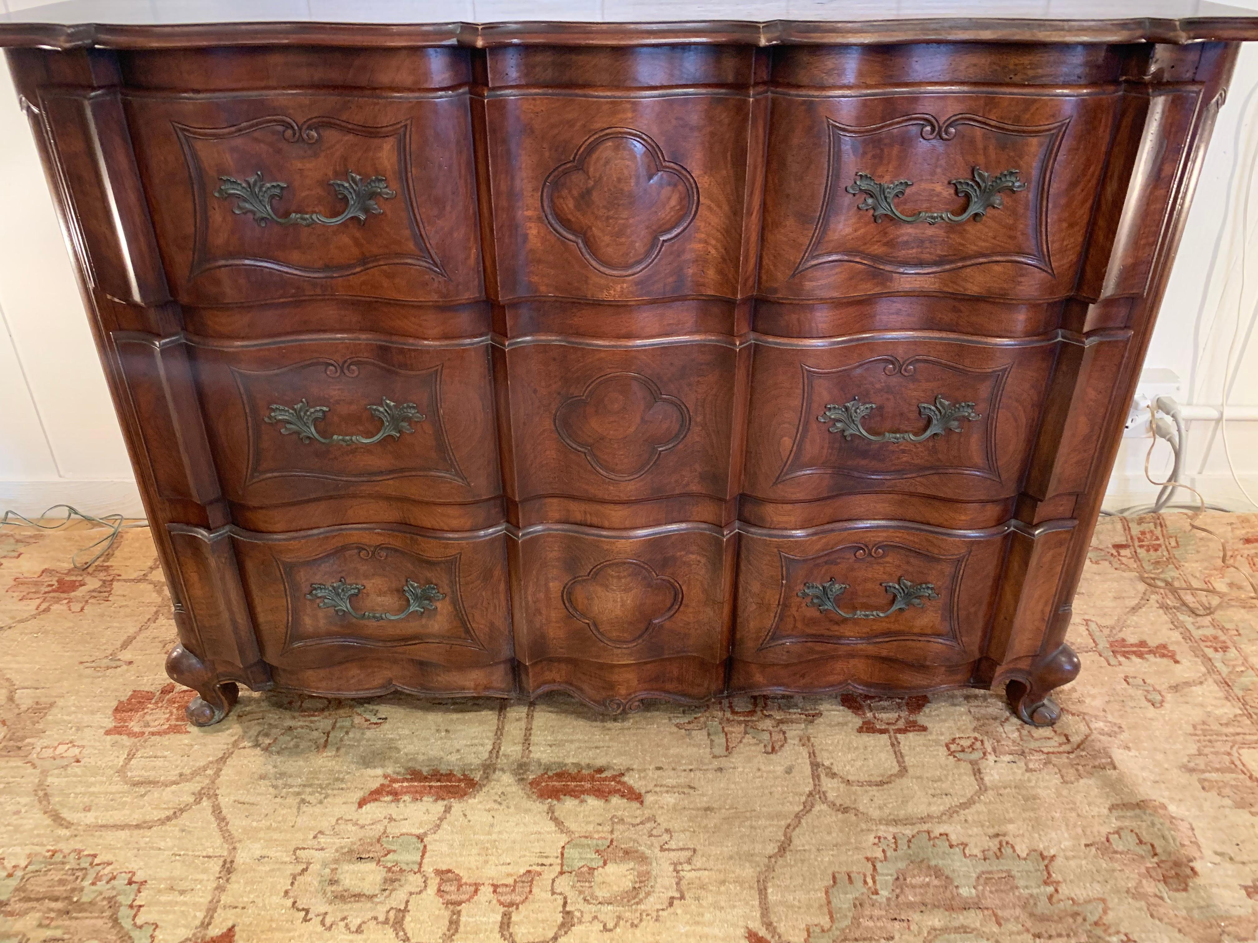 Handsome and solid mahogany dresser having serpentine front with conforming top and apron, resting on scroll feet. Its curvilinear form is enhanced by the inset panels on its sides and hand carved drawer fronts that include gorgeous beaded panels
