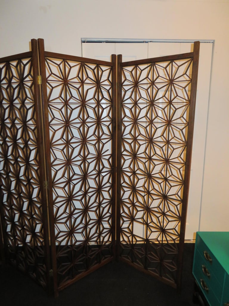 Handsome Mid-Century Modern 4 panel folding screen with starburst pattern. This unique Bohemian style four part lattice wall divider features the ability to fold up for convenience with each section is 24 inches wide. This unusual midcentury piece