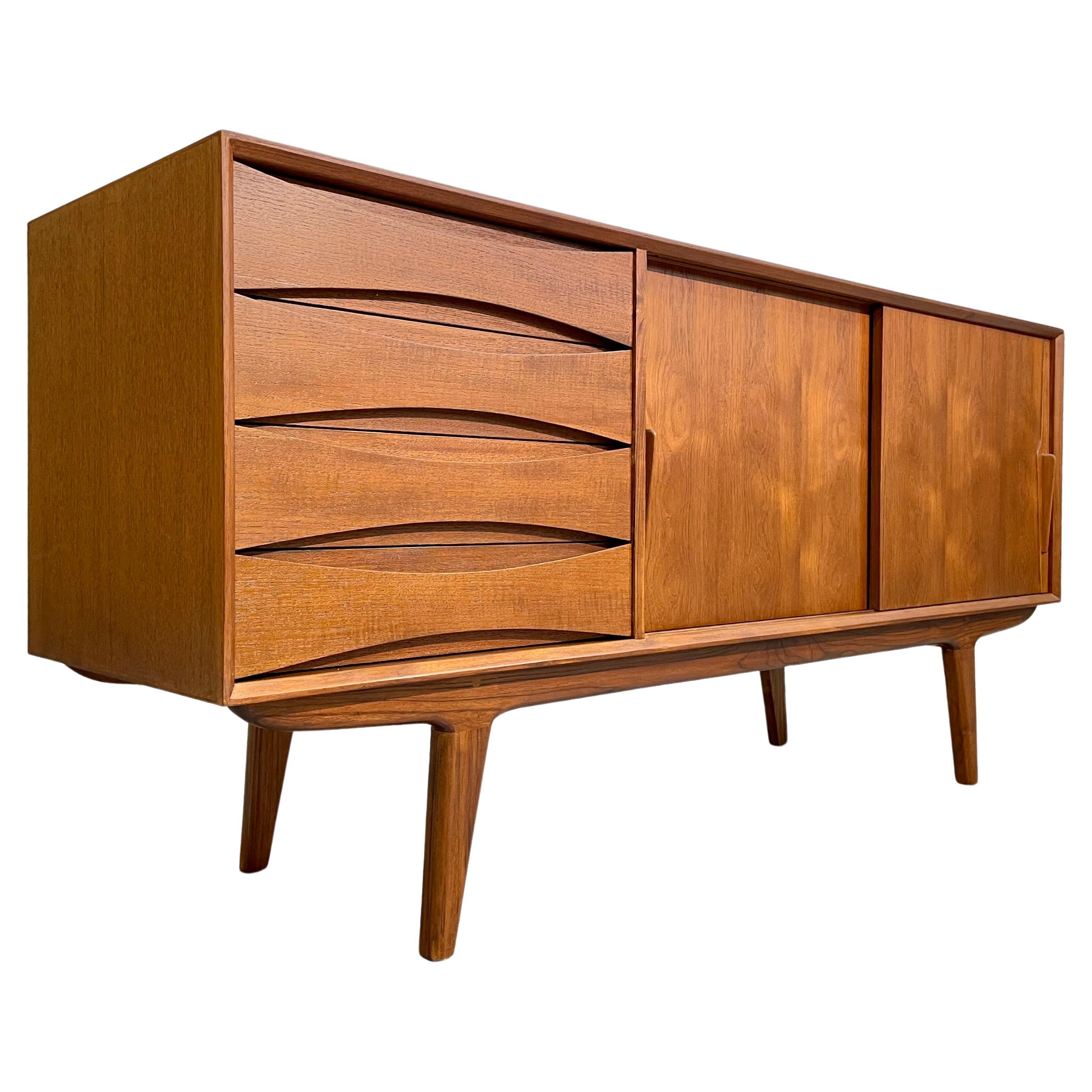 Mid Century Modern styled handcrafted Credenza / Media Stand. This beauty features exquisite knife-edge hand pulls and sculpted drawer fronts with slightly splayed legs. Stunning wood grains and finished back allow you to float the credenza in a