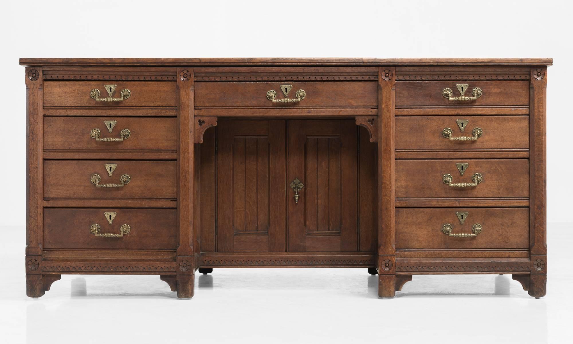 Handsome oak desk, England, circa 1870.

Sturdy construction with brass hardware and ornate detailing throughout. Made by Holland & Sons, London.