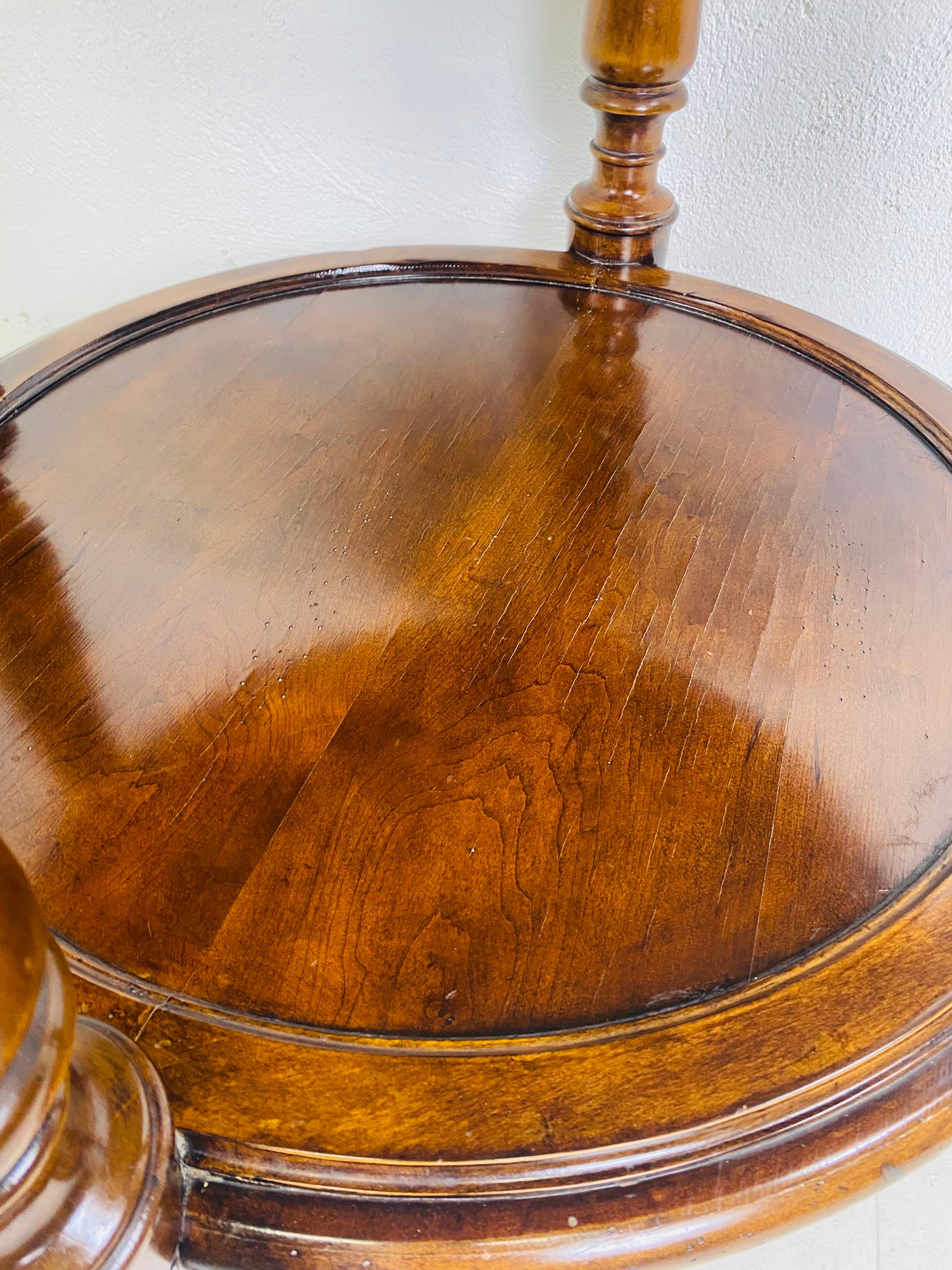 This is a vintage handsome dark walnut oversized side table. The side table has a beautiful glossy French polish style to the walnut and features a bottom shelf with four beautiful column legs. The side table was made by milling Road for the baker