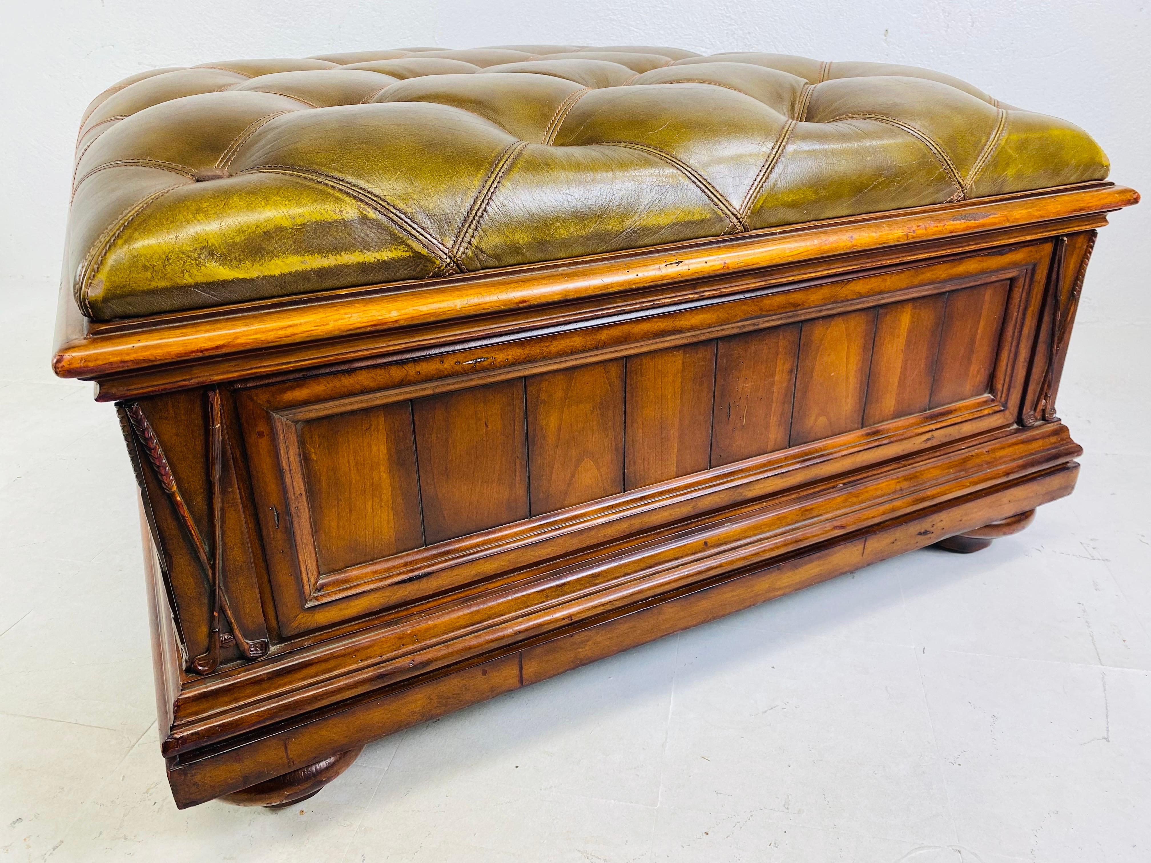 This is a handsome large oversized leather tufted library ottoman. The tufted ottoman features a beautiful olive green leather on the top and opens up to a finished walnut interior. The ottoman stands on four bun feet and has golf clubs carved into