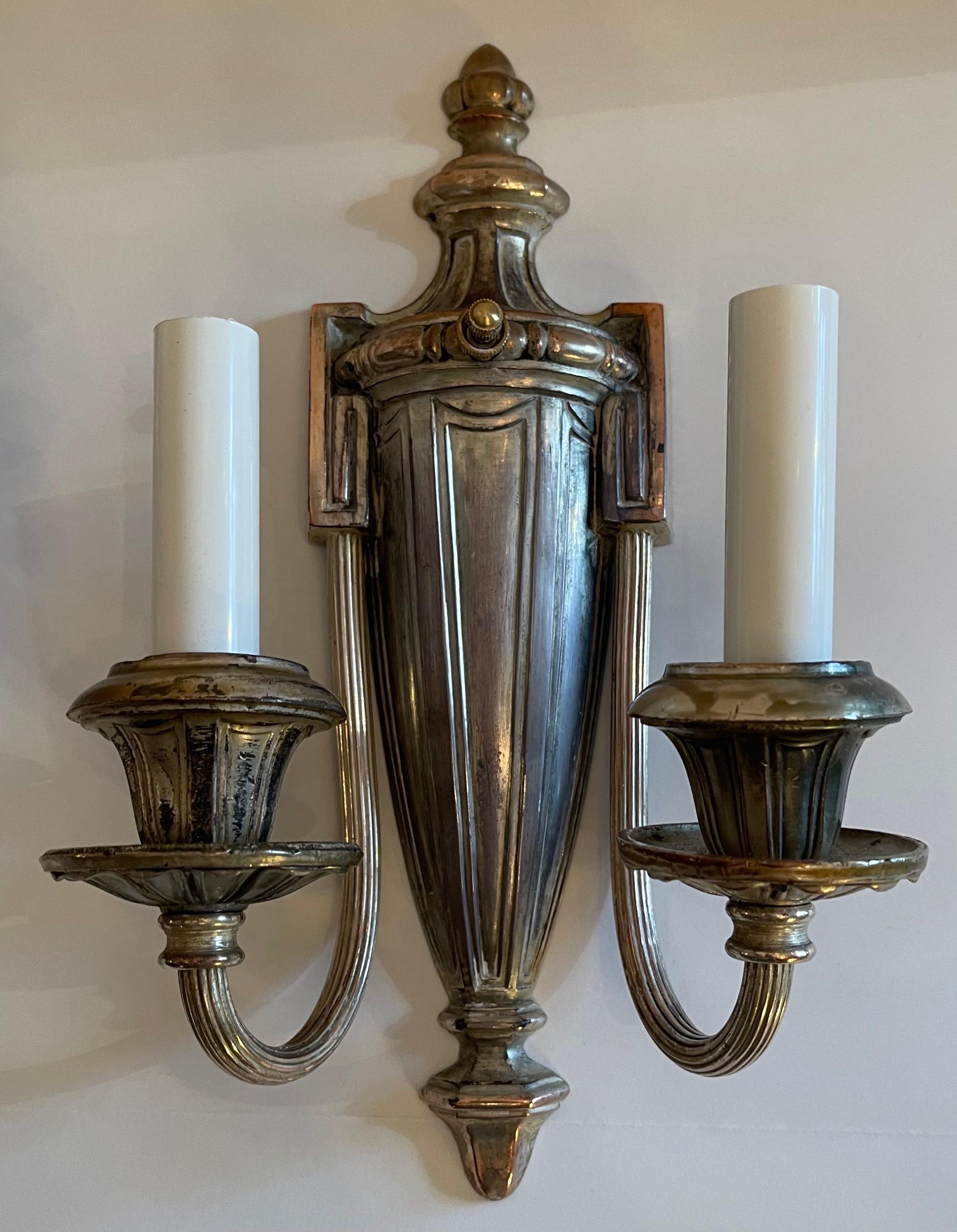 A handsome pair of Caldwell style silvered bronze Adams / Regency urn style two-light sconces rewired.