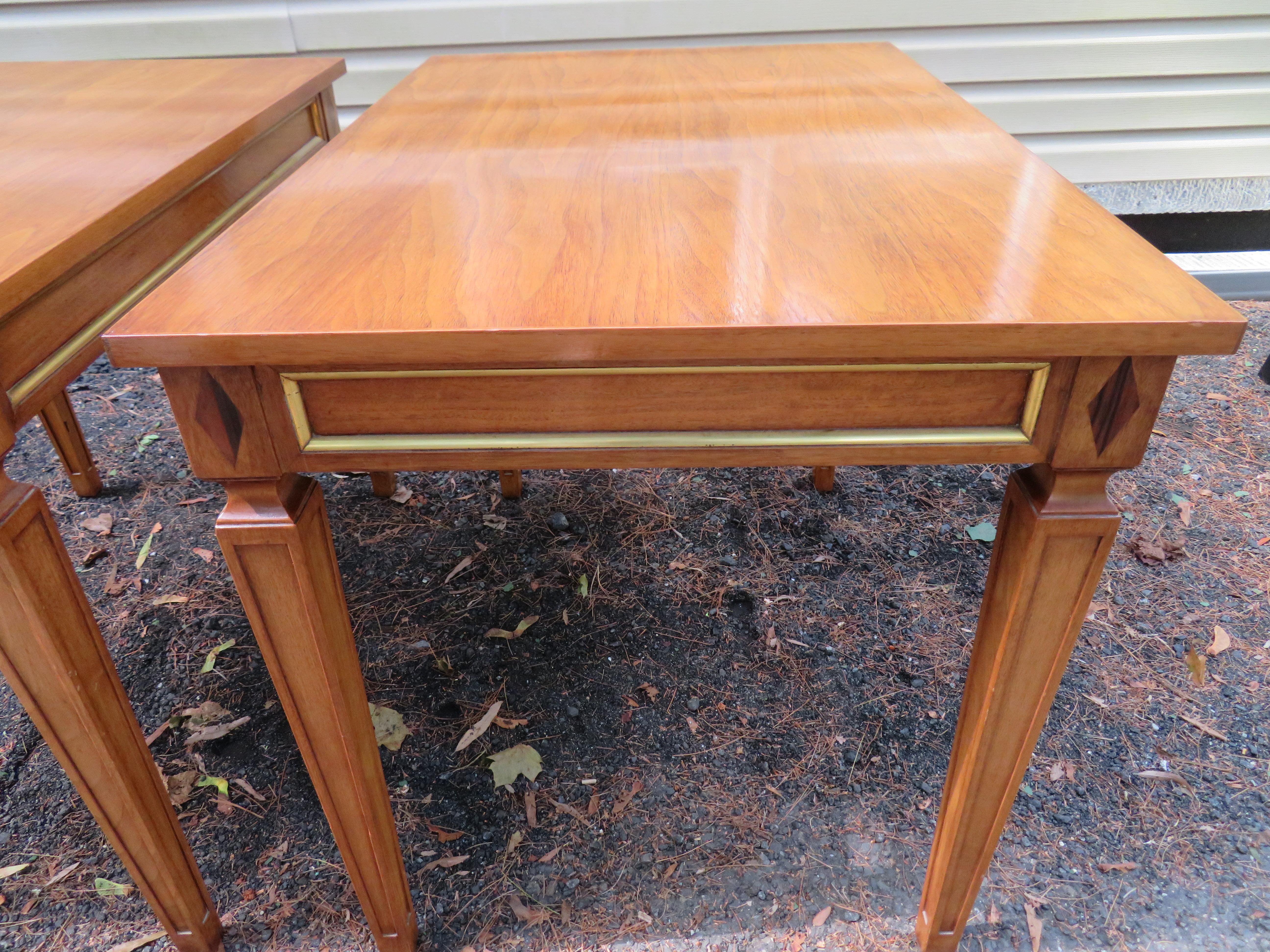 Handsome pair of Maison Jansen style walnut side end tables. These tables are well crafted and are in very nice vintage condition. They came from a magnificent home filled with the finest Regency modern furniture-looked like it was right out of a