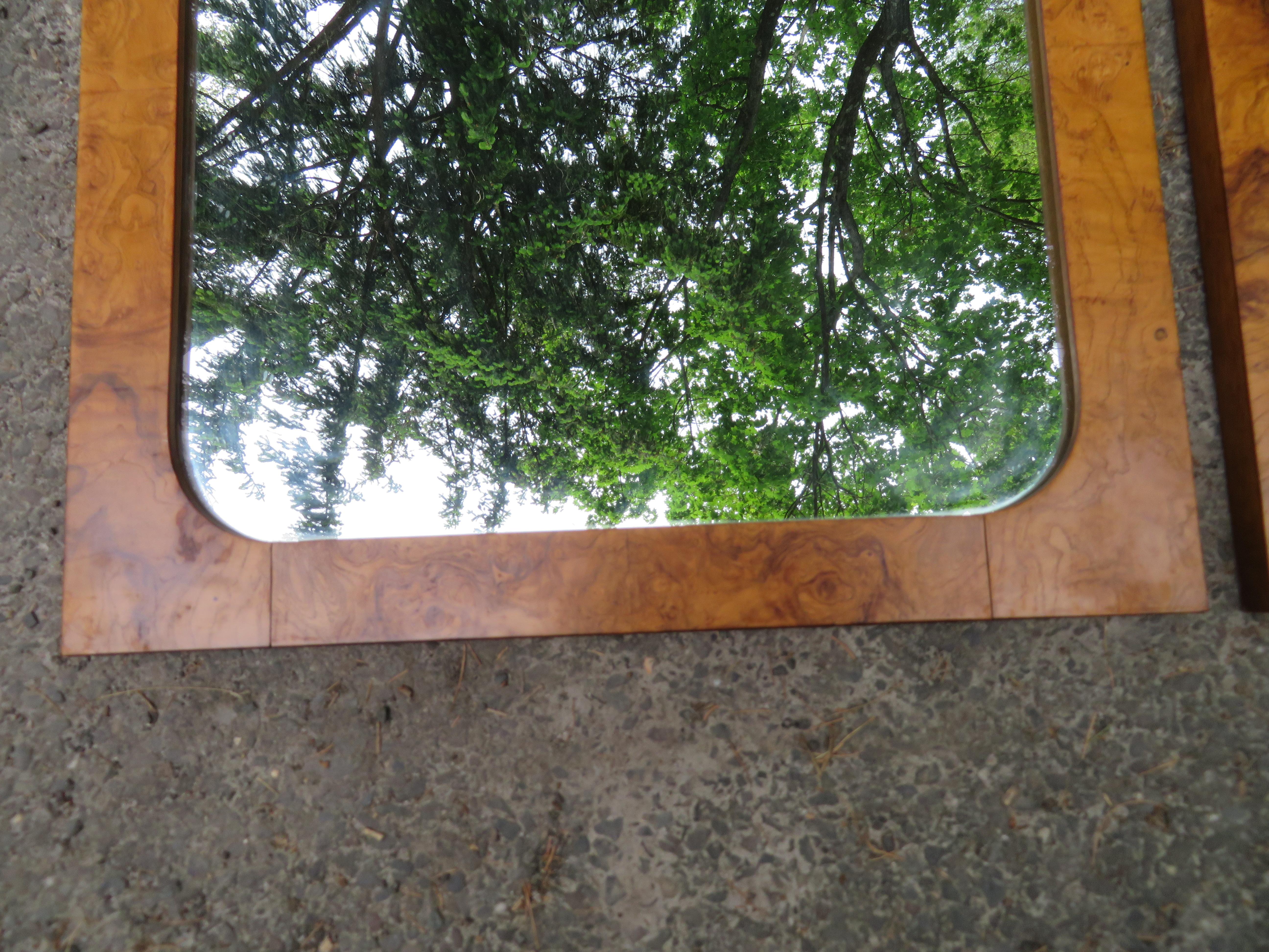 Handsome pair of vintage modern Roland Carter for Lane burl olivewood mirrors. Sleek rectangular design with elegant wood grain throughout makes these wonderful mirrors the perfect addition to any modern interior. One of the mirrors has a panel that