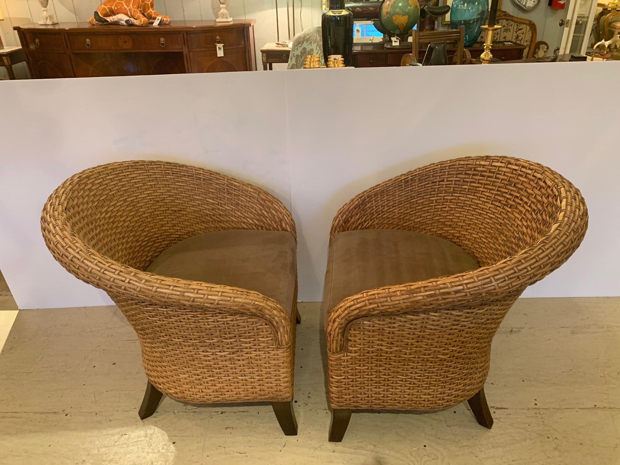 A handsome curvy barrel back shaped pair of woven rattan club chairs with custom seat cushions.

Size: Seat 20” D x 18” H.