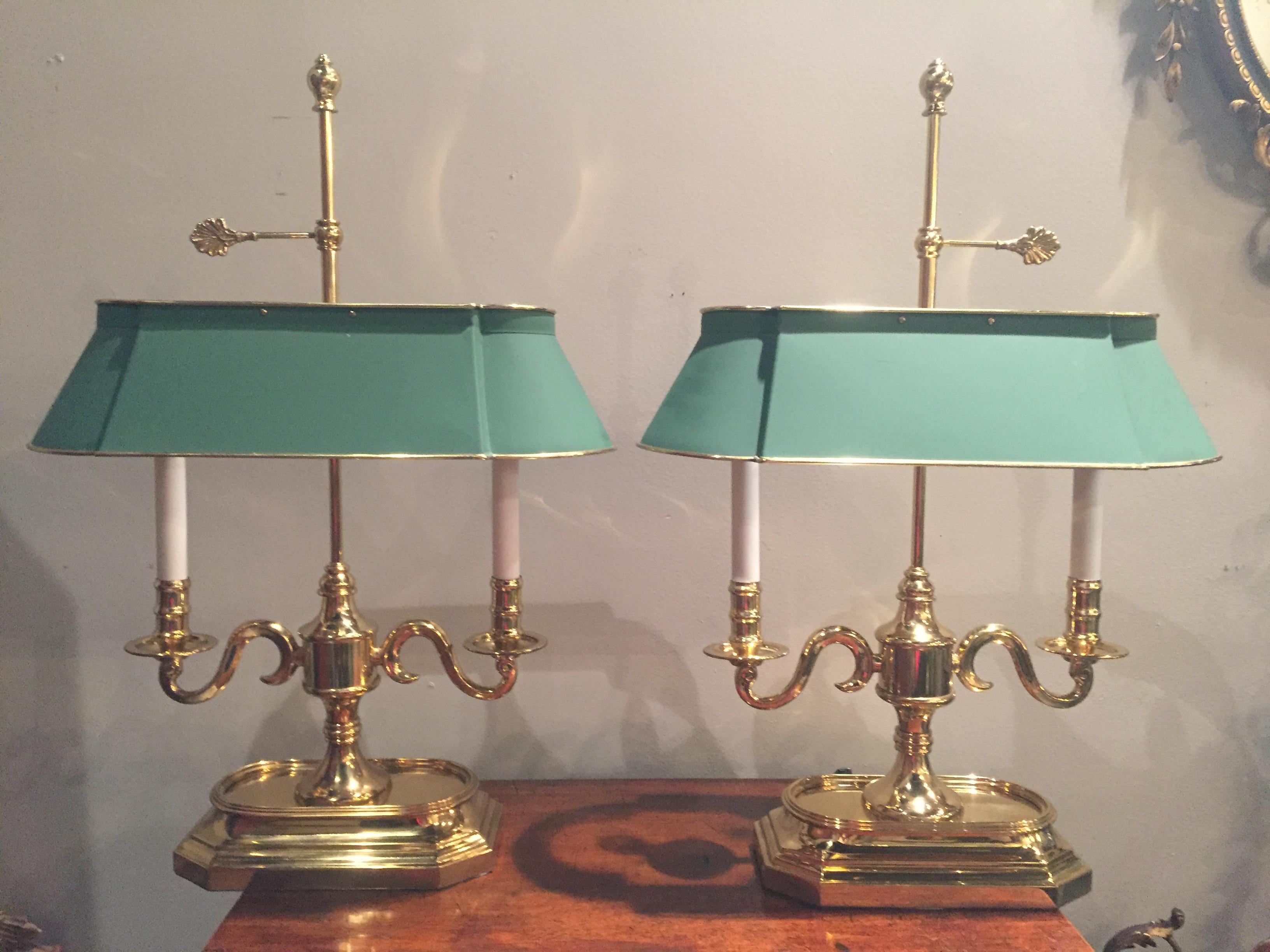A quality pair of brass two-arm candlestick table lamps with handsome green painted brass lamp shades, decorative finials and screw key to adjust shade height. B0ase is 10 x 6.
  