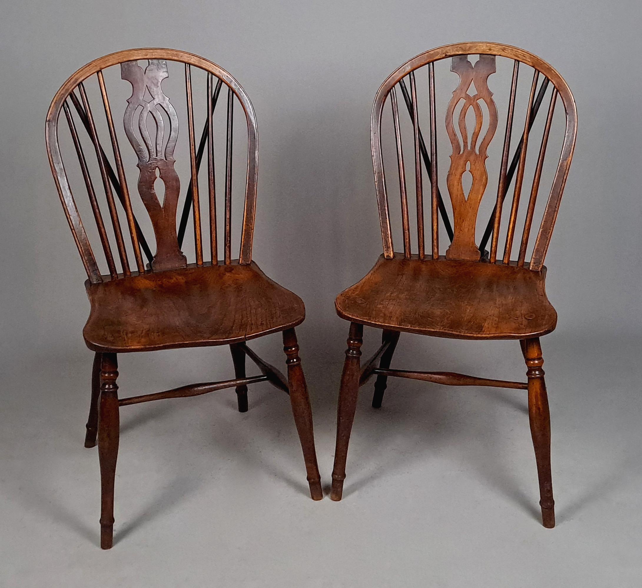 With a beautiful natural colour, a true pair of stick back Windsor chairs with fret carved splats and original fine and slender spindles.

With well shaped solid elm saddle seats and both chairs with great patina.  All of the legs original and