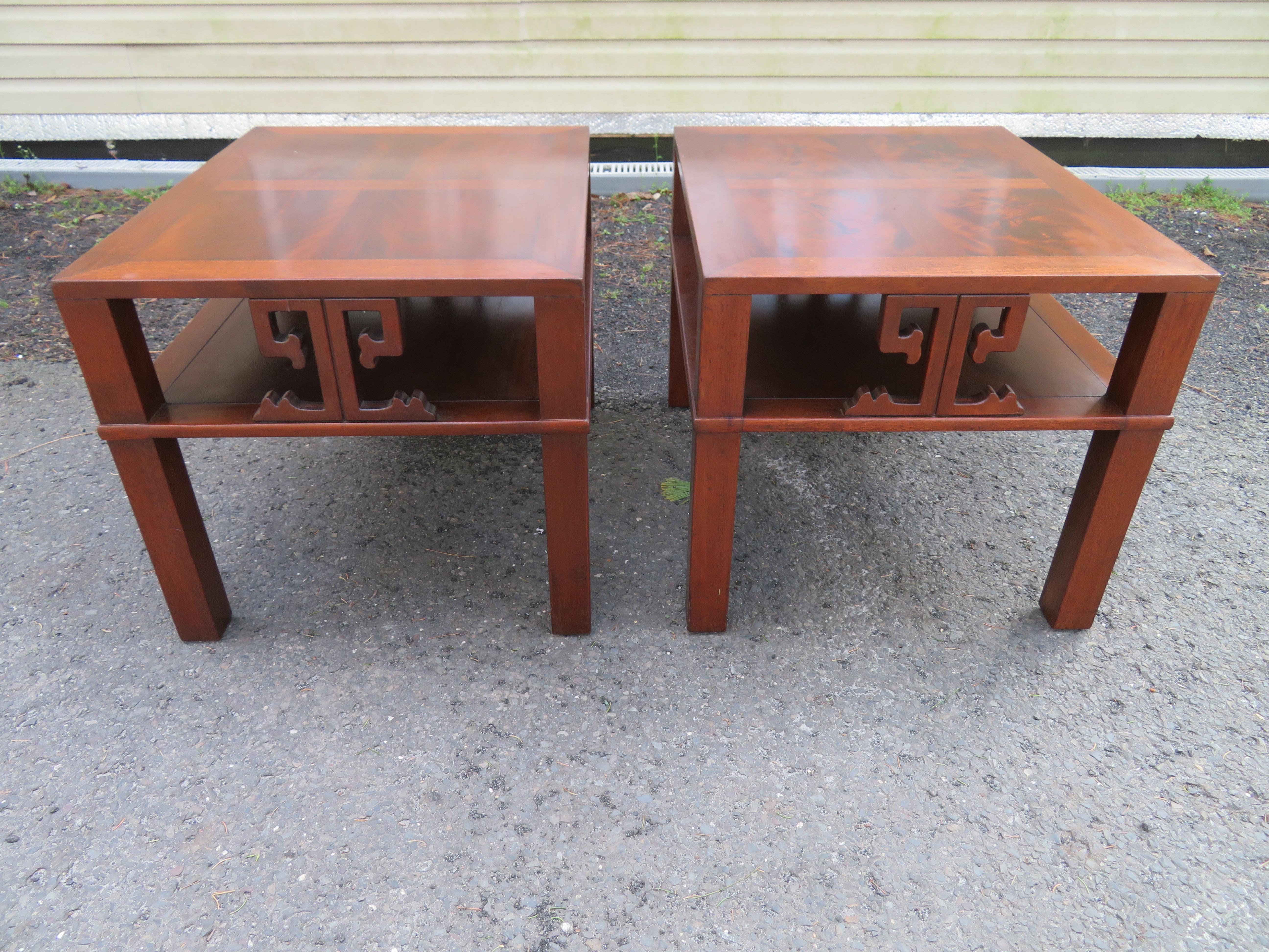 Handsome pair of Asian style parsons end table/ night stands by Heritage Henredon, circa 1960. Wonderful flame mahogany top with a lovely Asian influenced Greek Key motif. Beautifully conceived design with excellent attention to detail. These tables