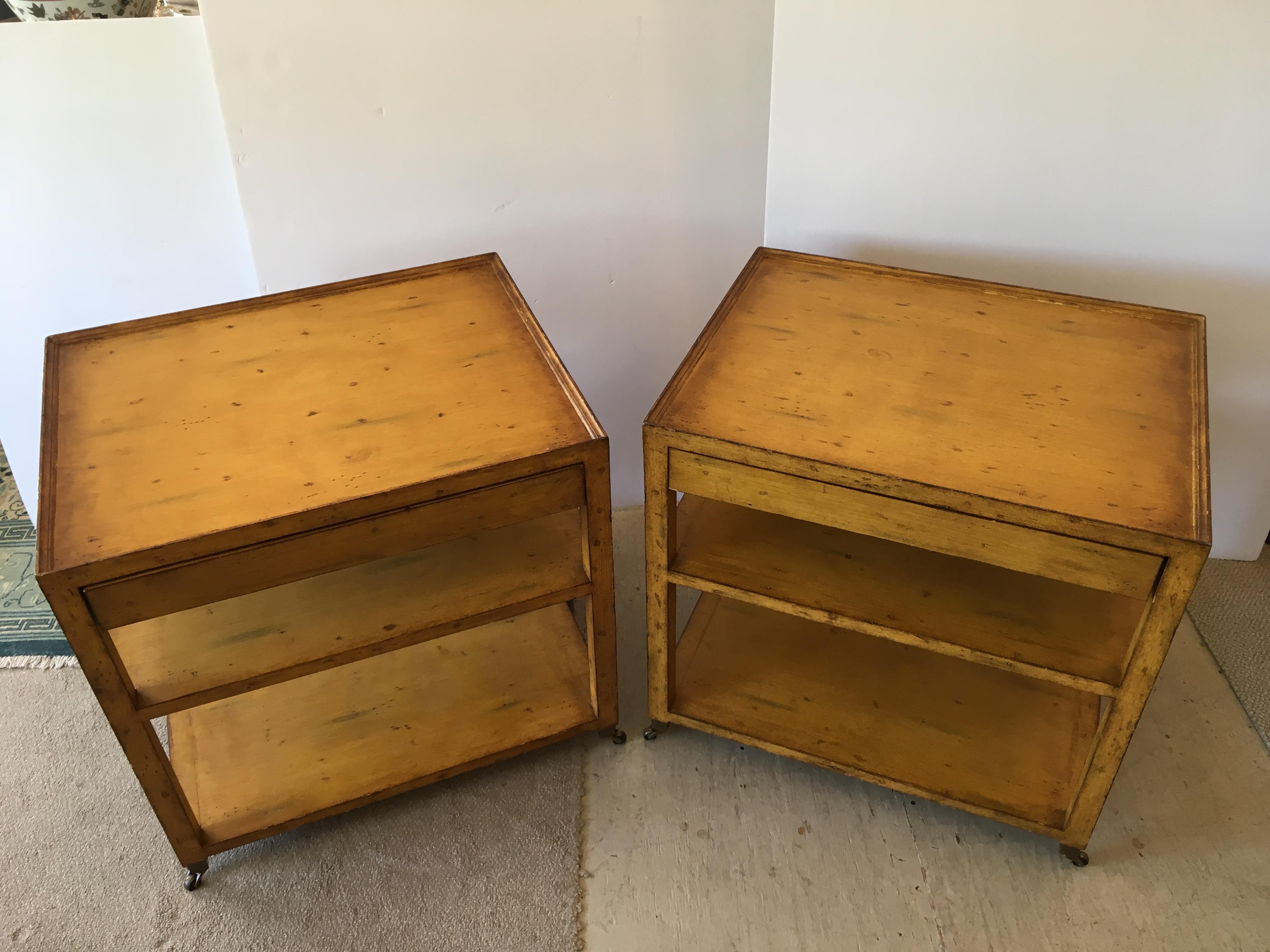 A great looking pair of mustard painted mahogany nightstands, solid in construction, having 3 tiers, single drawer and brass casters.
