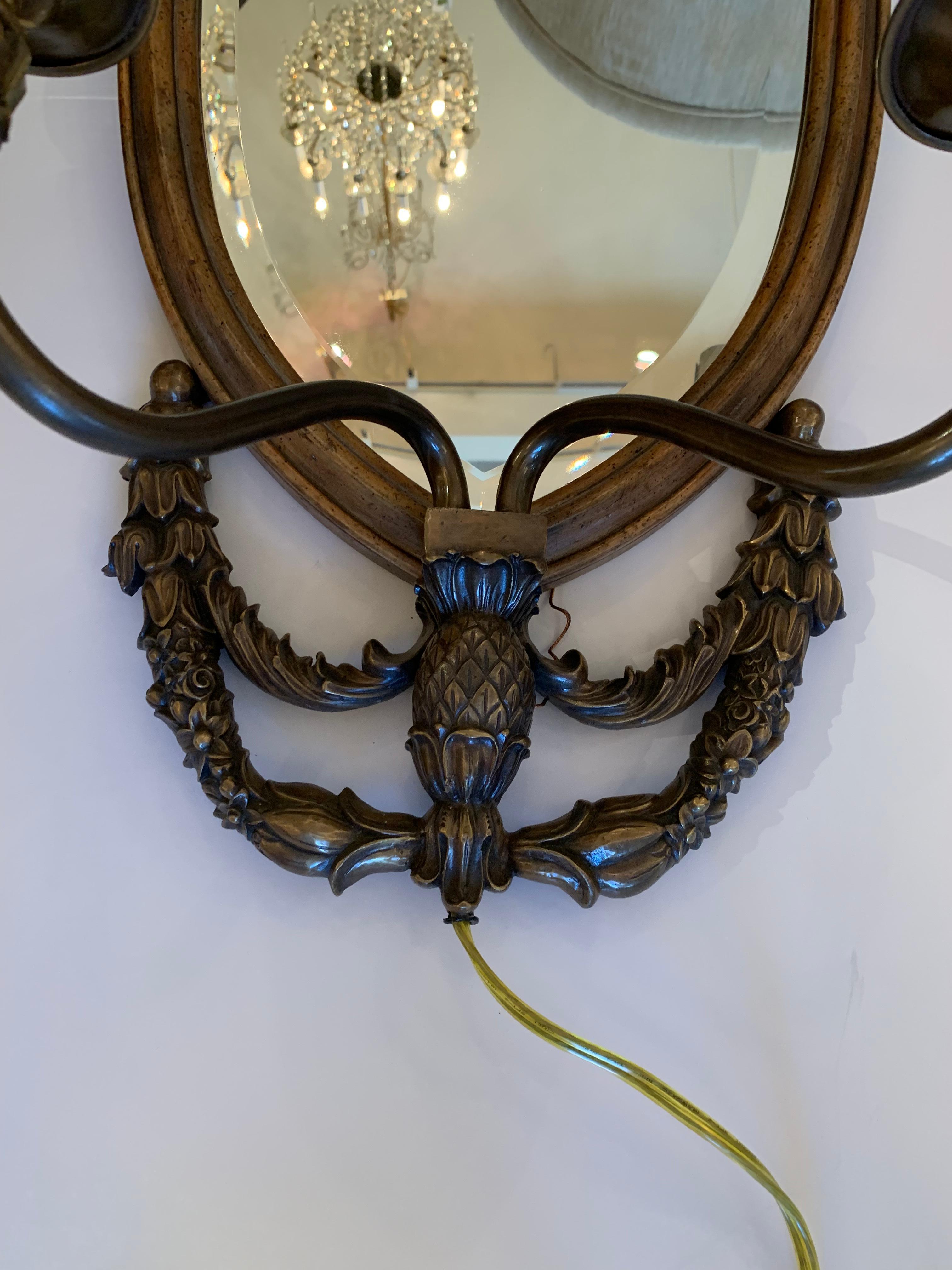 Pair of impressive shield back mirror two-arm sconces by Maitland Smith having neoclassical bronze figural medallion top. 

 