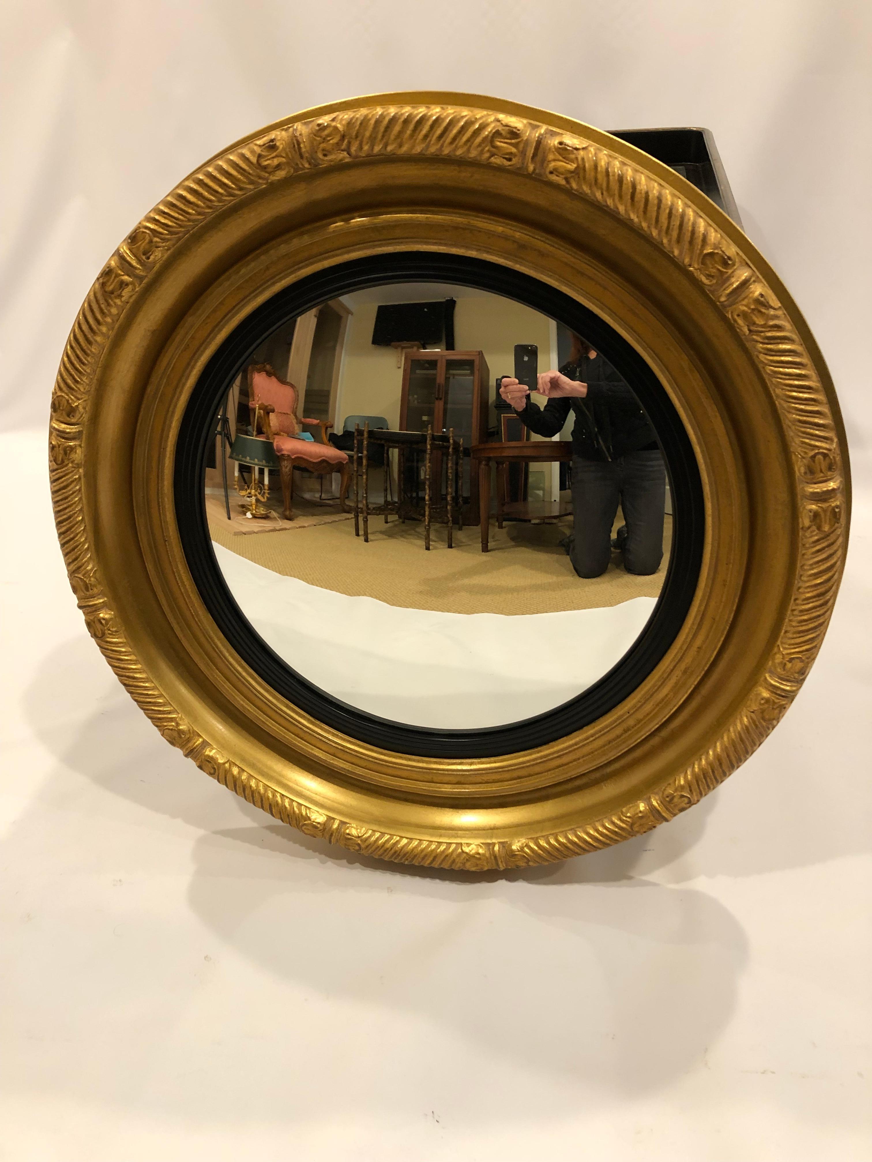 Classic round bullseye convex mirror by Carvers Guild having giltwood frame and contrasting black interior border. Measure: Mirror is 15.75 diameter.