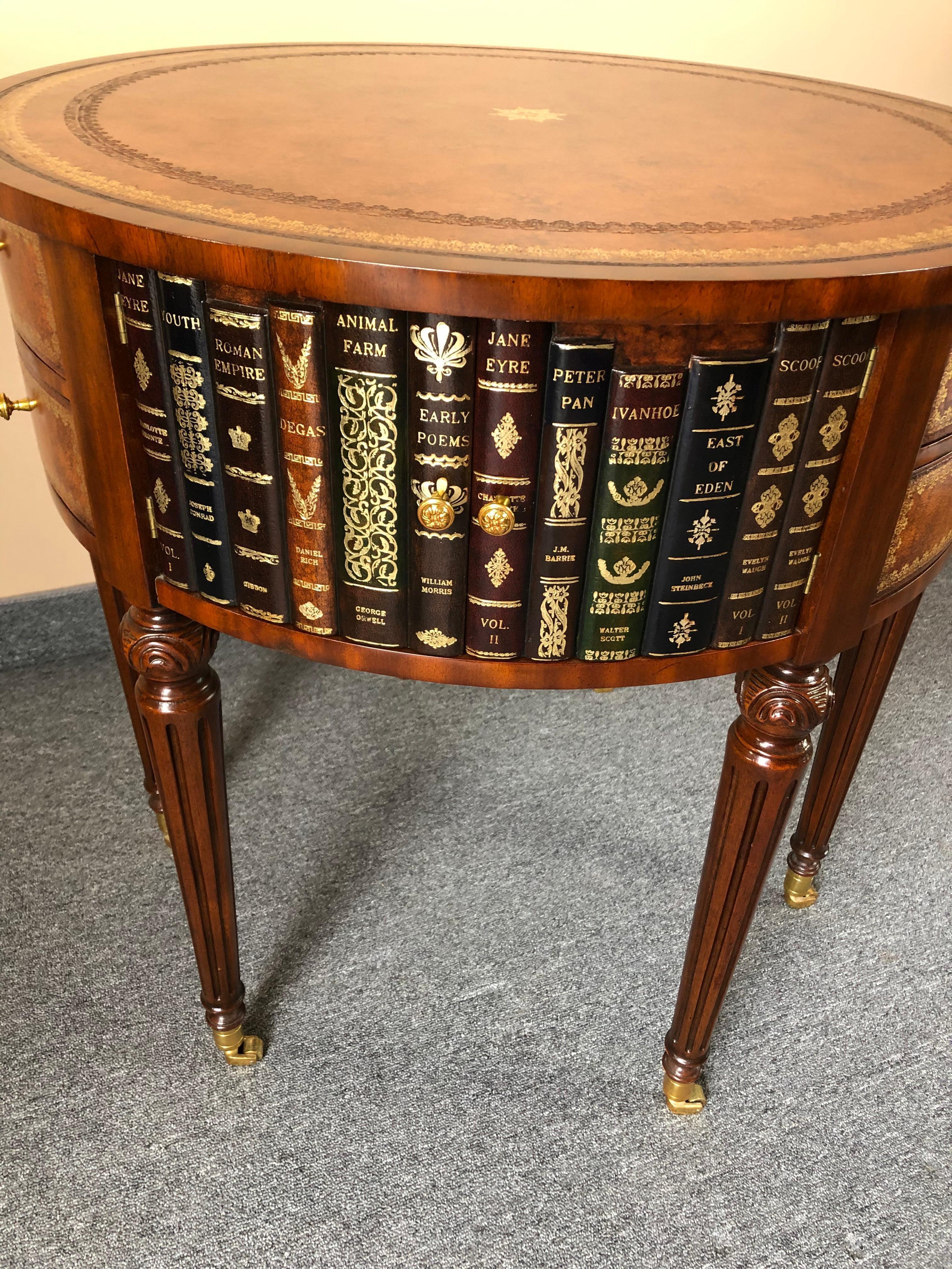 Stylish round side or end table having tooled leather top and trompe l'oeil leather books around the body with 6 drawers in total and 3 doors that open to reveal storage inside.
Tapered carved mahogany legs terminate in brass casters.