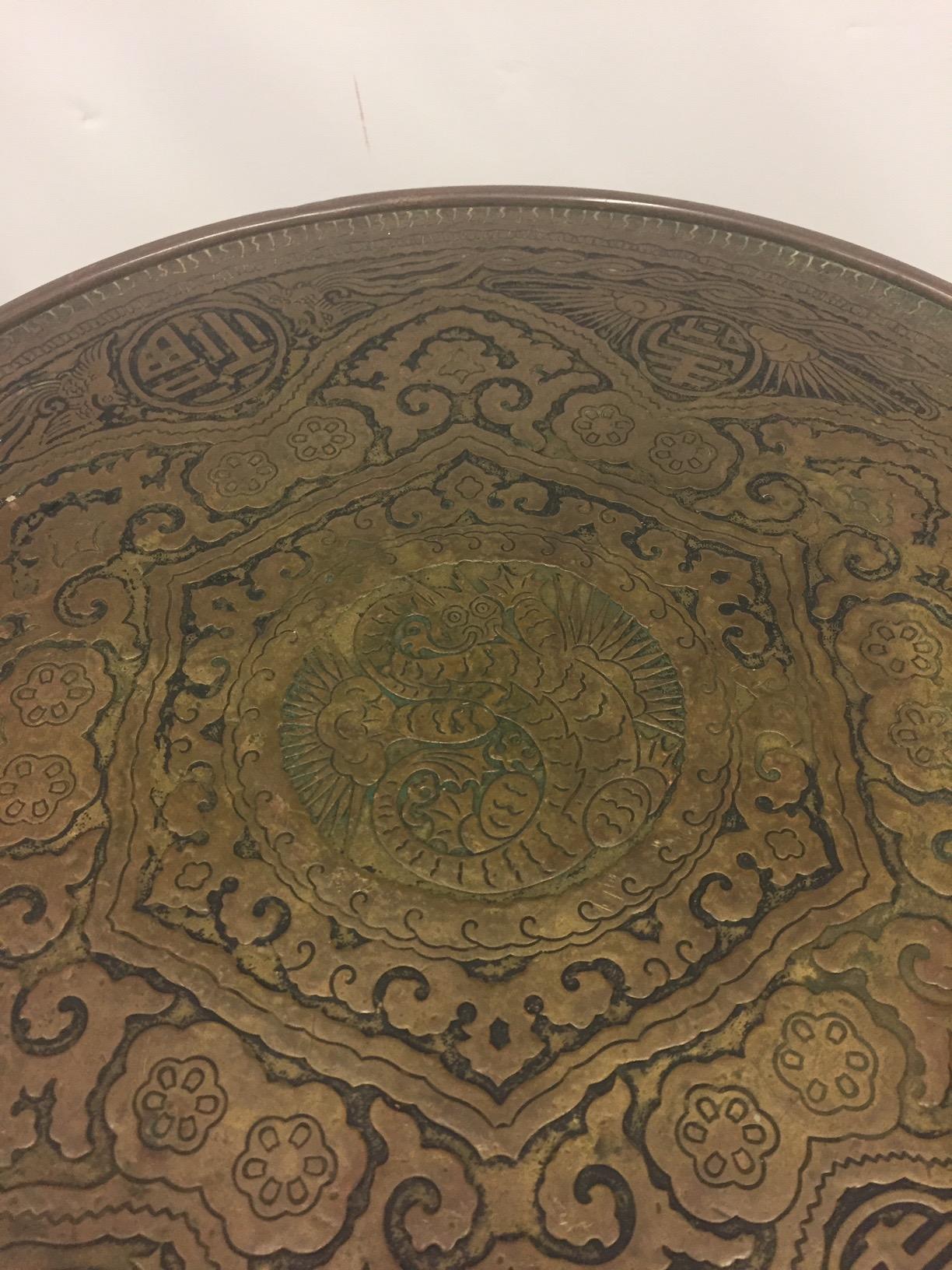 Handsome small round drinks table having mahogany barley twist base and gorgeous embossed brass top with an oriental motife.