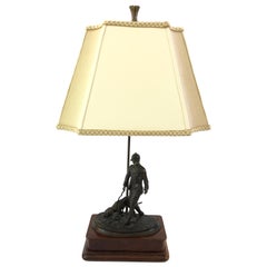 Magnifique lampe de table sculpturale en bronze représentant un chasseur avec un chien de chasse