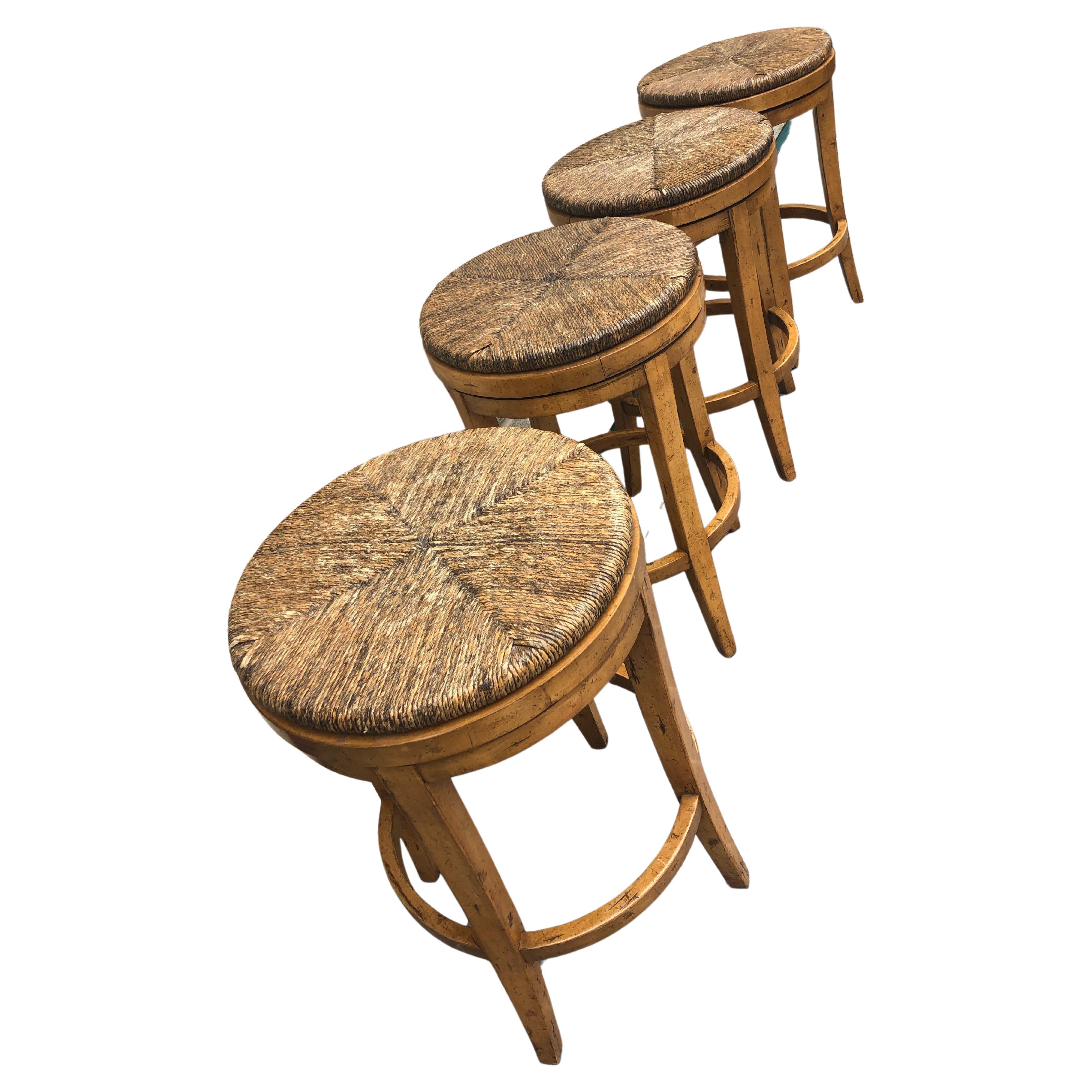 Impressive set of comfortable sturdy Hyde barstools by Guy Chaddock. Handsome wood bases with rush seats that swivel.