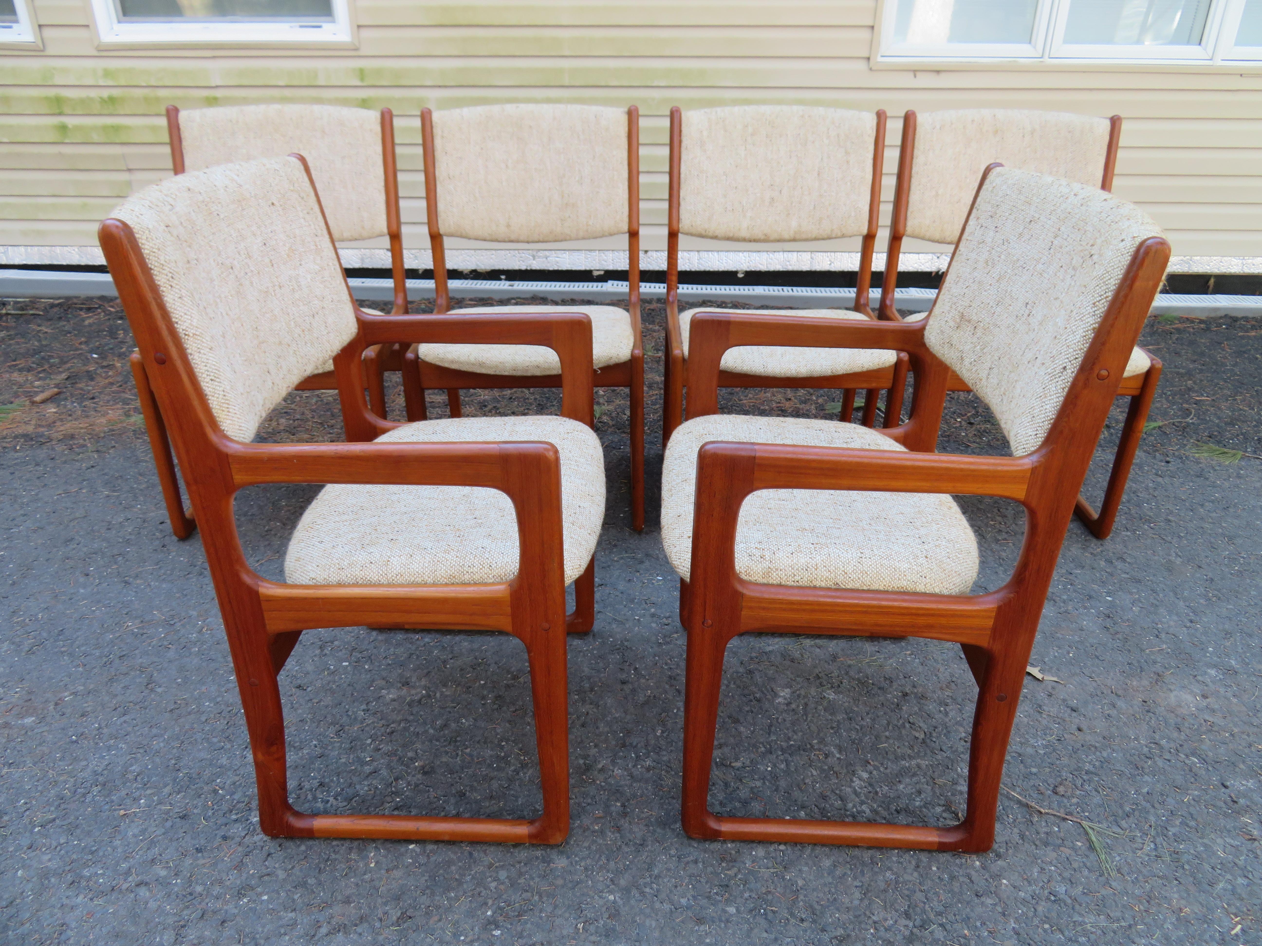 Exceptionally handsome set of six Danish modern teak dining chairs. Distinguishing features included beautifully sculpted arms and legs, amply padded backrest and bottom cushions, floating seat. Solid teak construction. Sleek Danish Modern design,