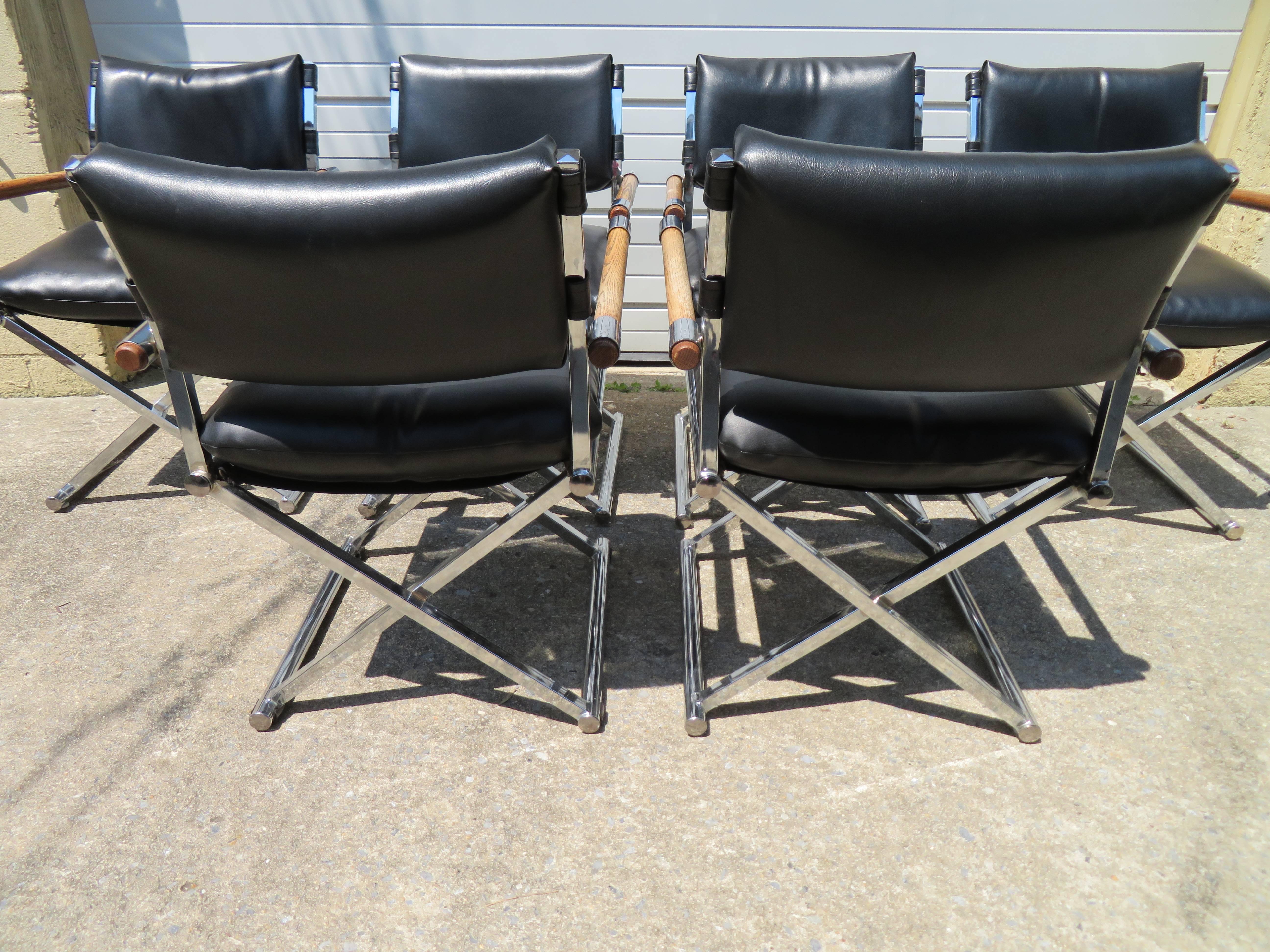 A vintage set of six director's dining chairs in black faux leather with chrome X-base frames and wooden arm rests attributed to Milo Baughman. Each chair measures 32.5