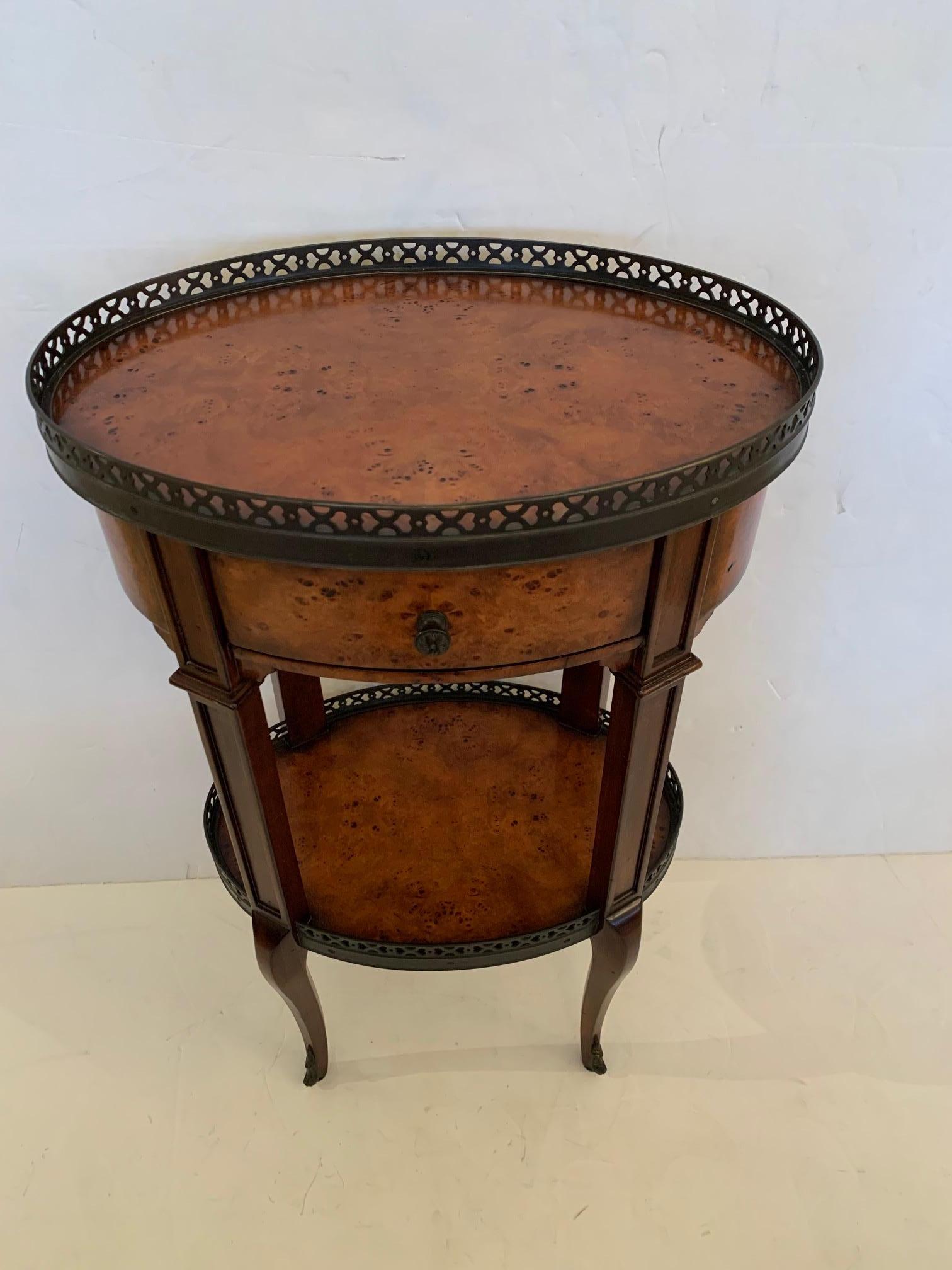 Stunning and versatile oval 2 tier walnut side table having pierced brass gallery, single drawer and cabriole legs.