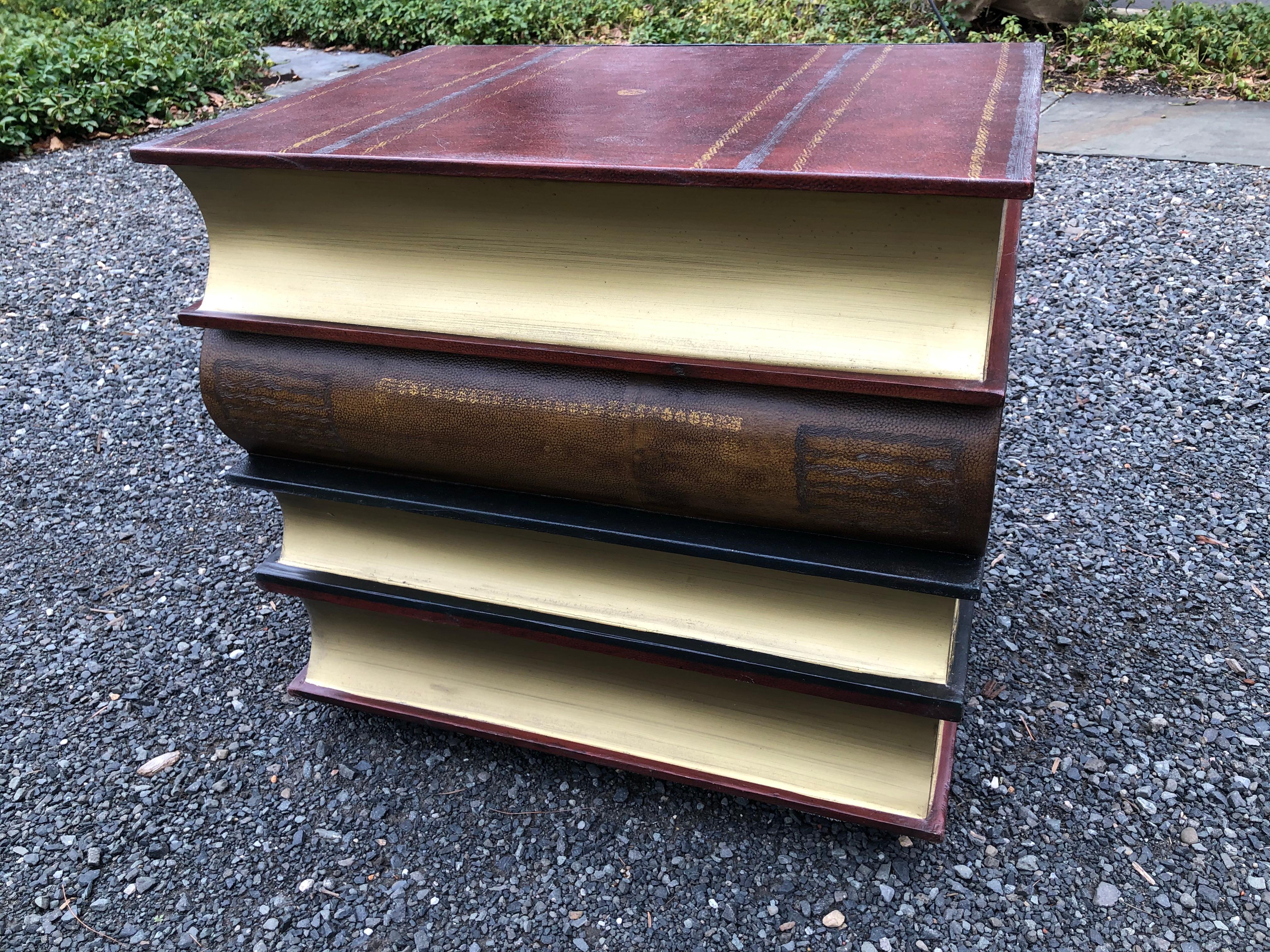 A handsome side or accent table in the form of a stack of leather books and having a single drawer in the top book.
  