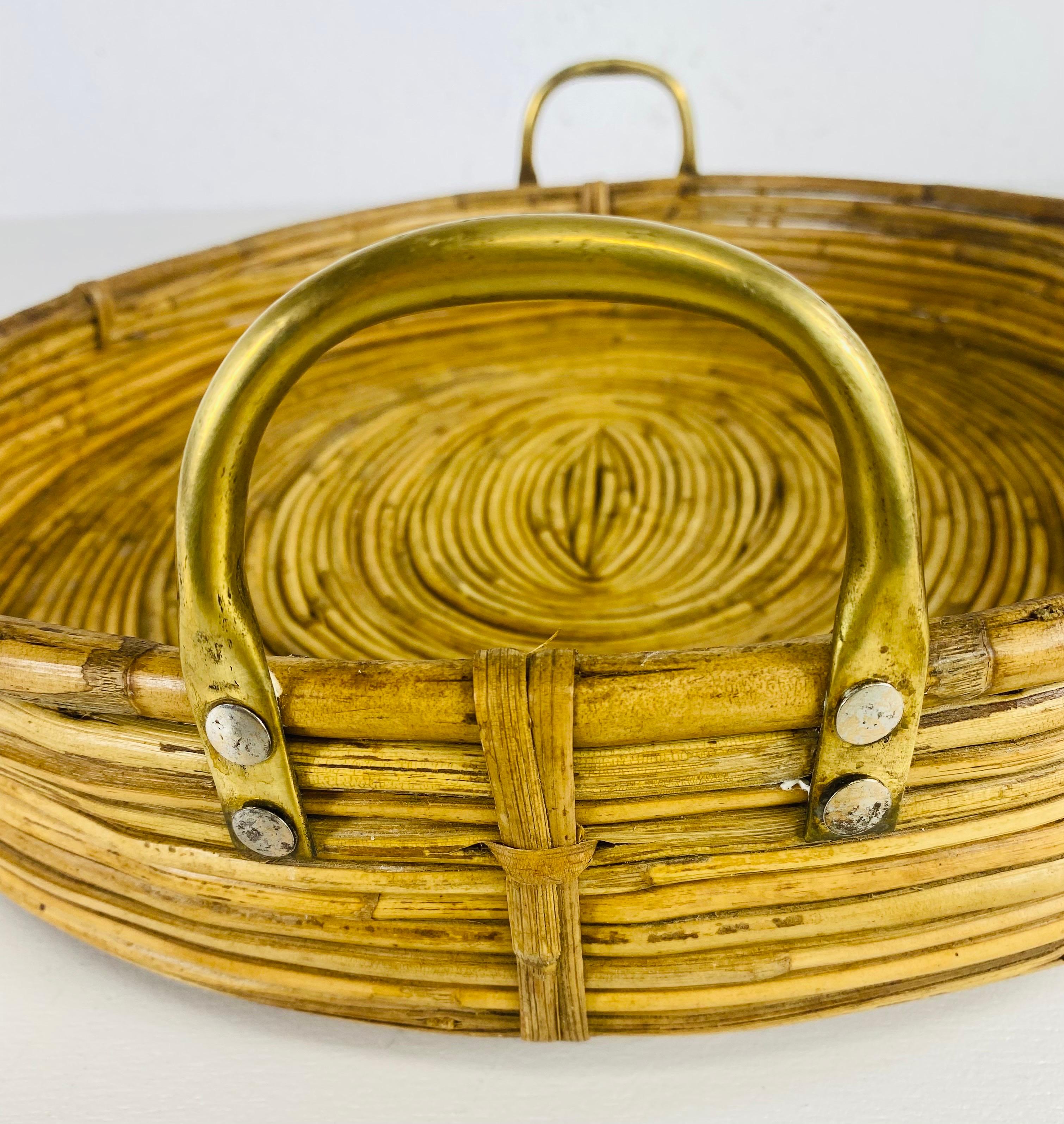 This is a vintage coastal read bamboo serving tray. This handsome serving tray has two arched brass handles on either side with a read base giving the tray a slight elevation off of the table.