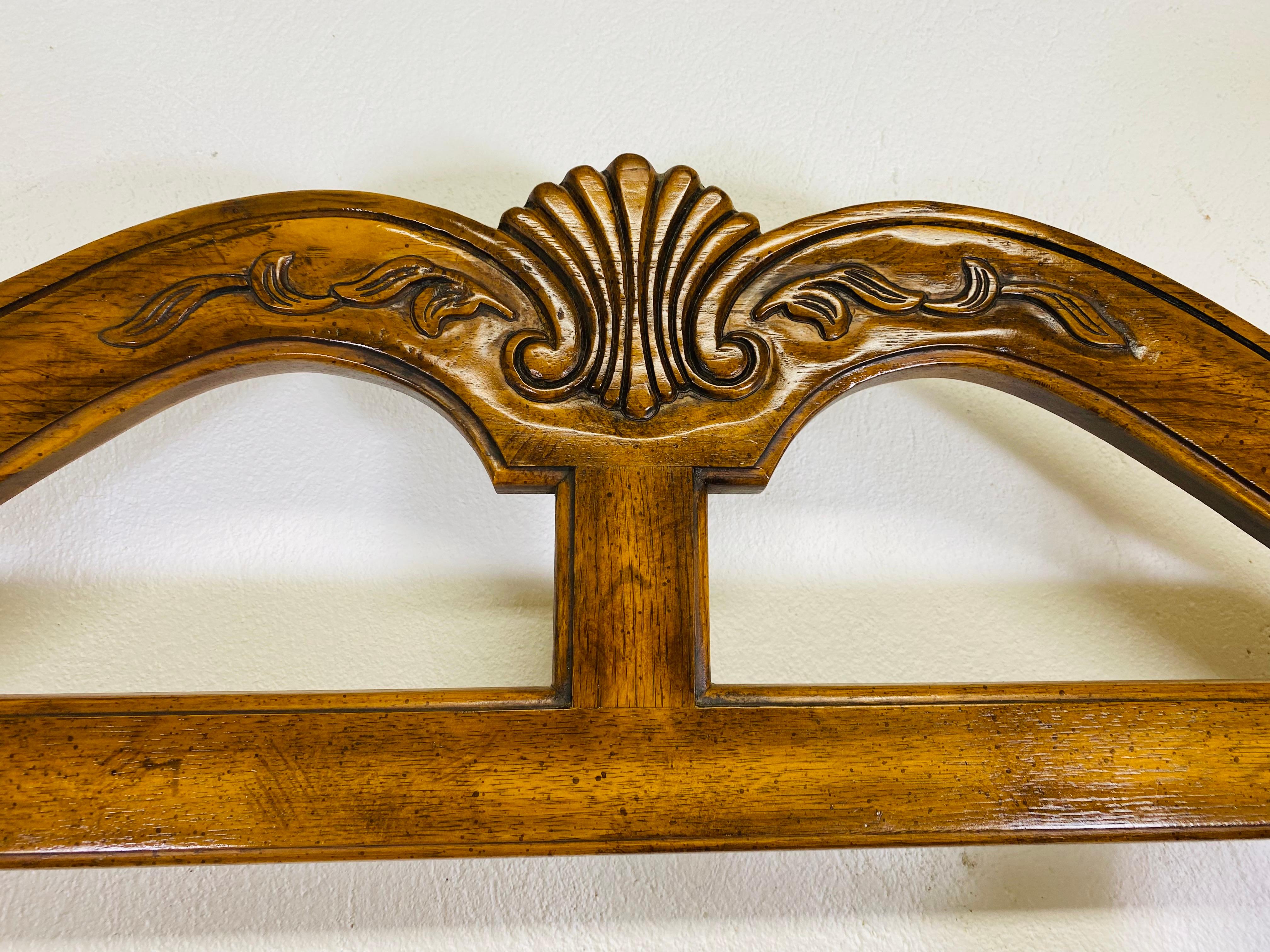 This is a mid-century vintage brass and walnut Bakers rack. The bakers rack has beautiful brass scrolled details on each shelf. The front of each shelf has brass trim to give it a glossy finish. The bakers rack has a hand carved French provincial