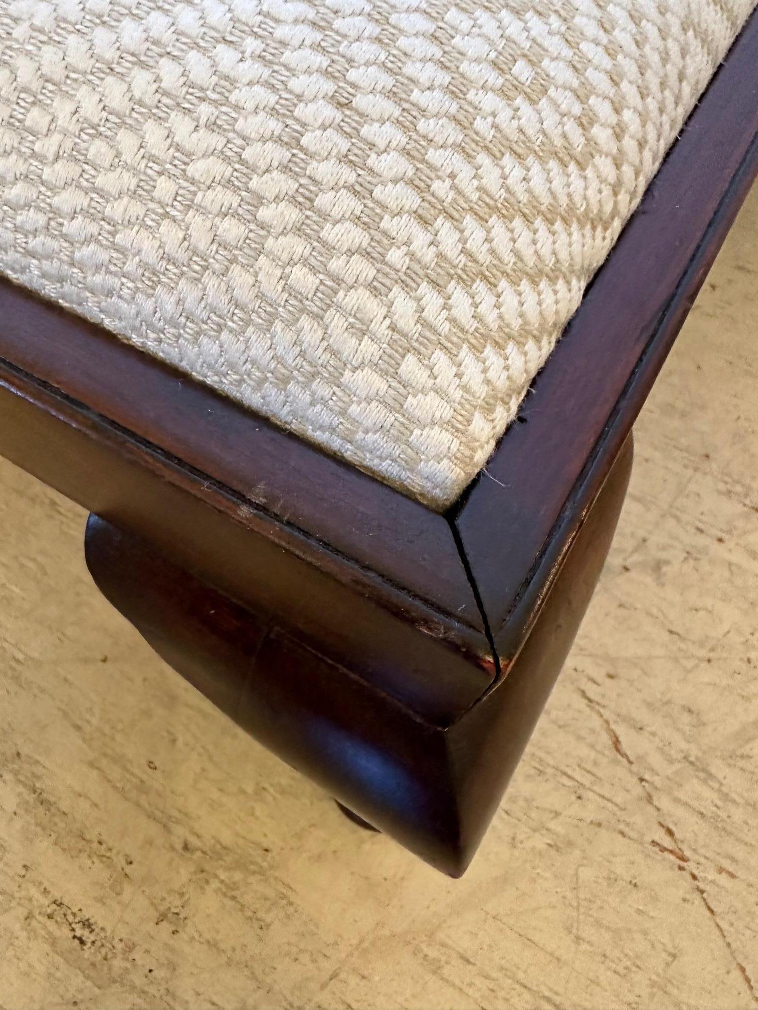 Handsome rectangular low to the ground antique footstool having dark wood base with stylishly flaired cabriole feet and new neutral geometric woven upholstery.