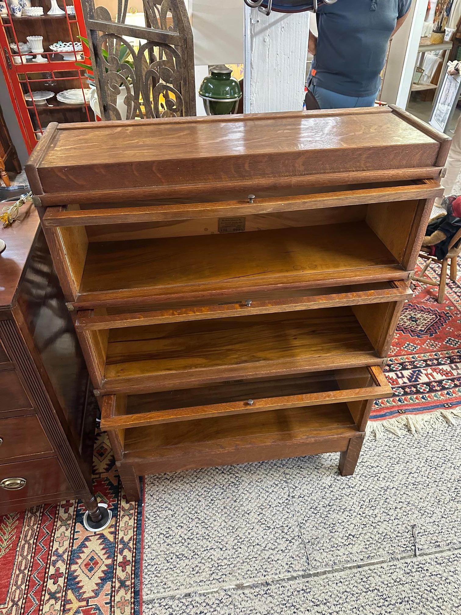 Bellissima libreria a 3 scomparti/scaffali in Oak, con frontali in vetro che si aprono e scorrono nella parte superiore dello scaffale.   Le cinghie in ottone sui lati sono un bel dettaglio.
5 pezzi singoli
In alto
3 ripiani e piedini