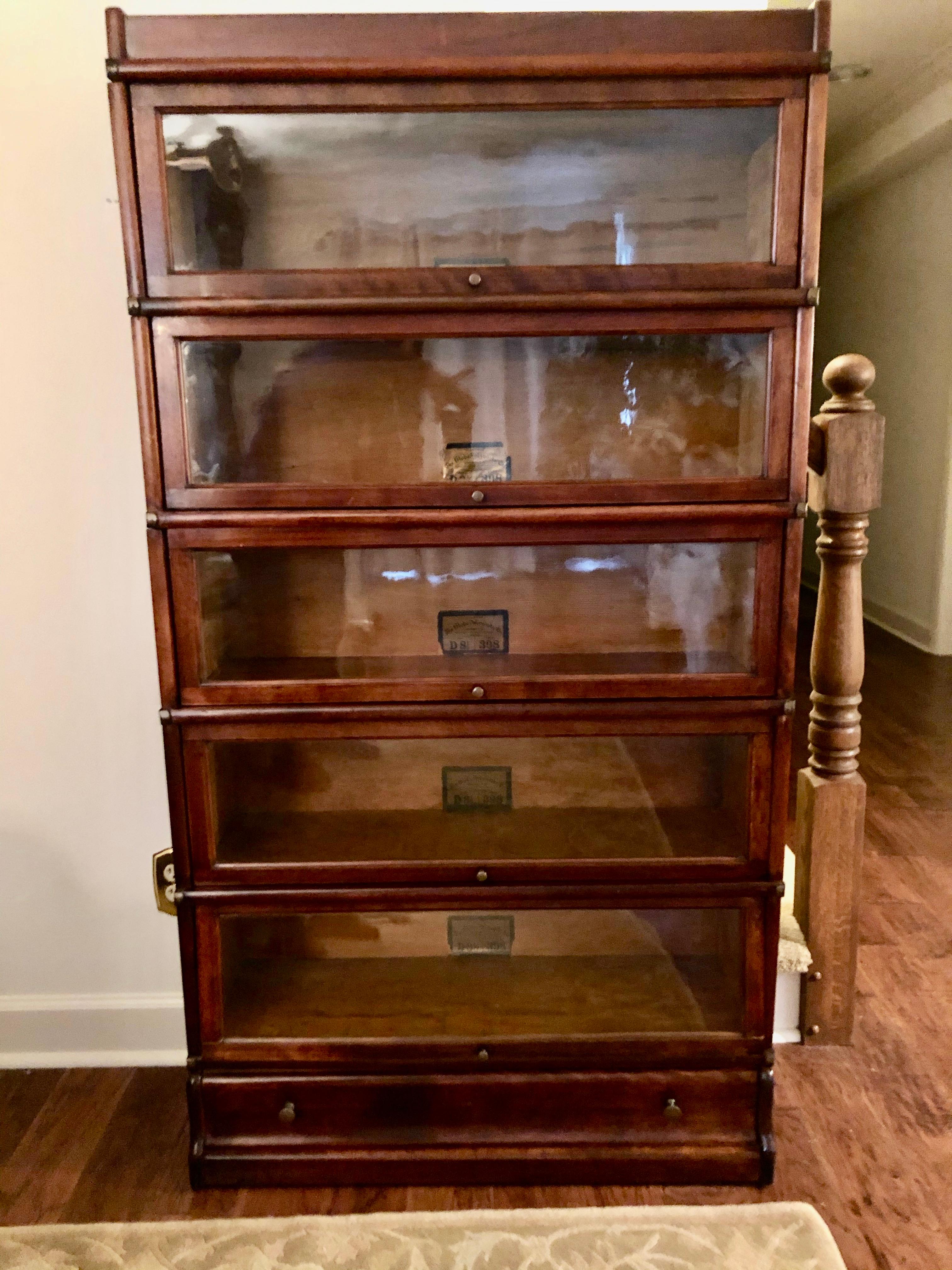Terrific 7 section stacking oak barrister bookcase having 5 glass front compartments for storage and a header and footer piece. Created by the renowned Globe-Wernicke Co. One storage drawer at the bottom.
Measurements of each box taken from front