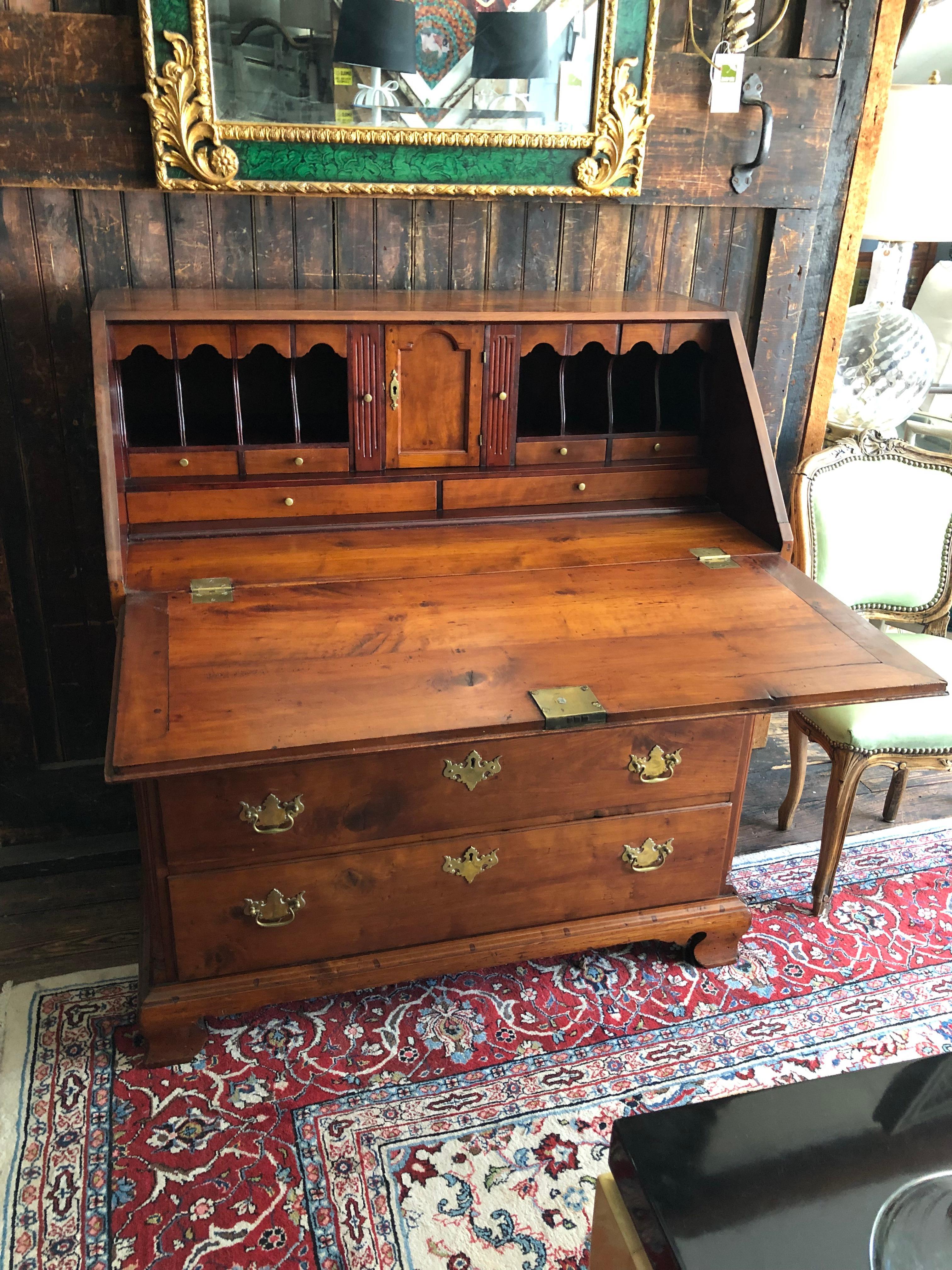 Handsome very early antique American slant front cherry desk having wonderful warm patina, original brass Chippendale style hardware and fantastic array of working drawers, cubbies and a little door on the  inside.  Roomy writing surface,
 23.75 d