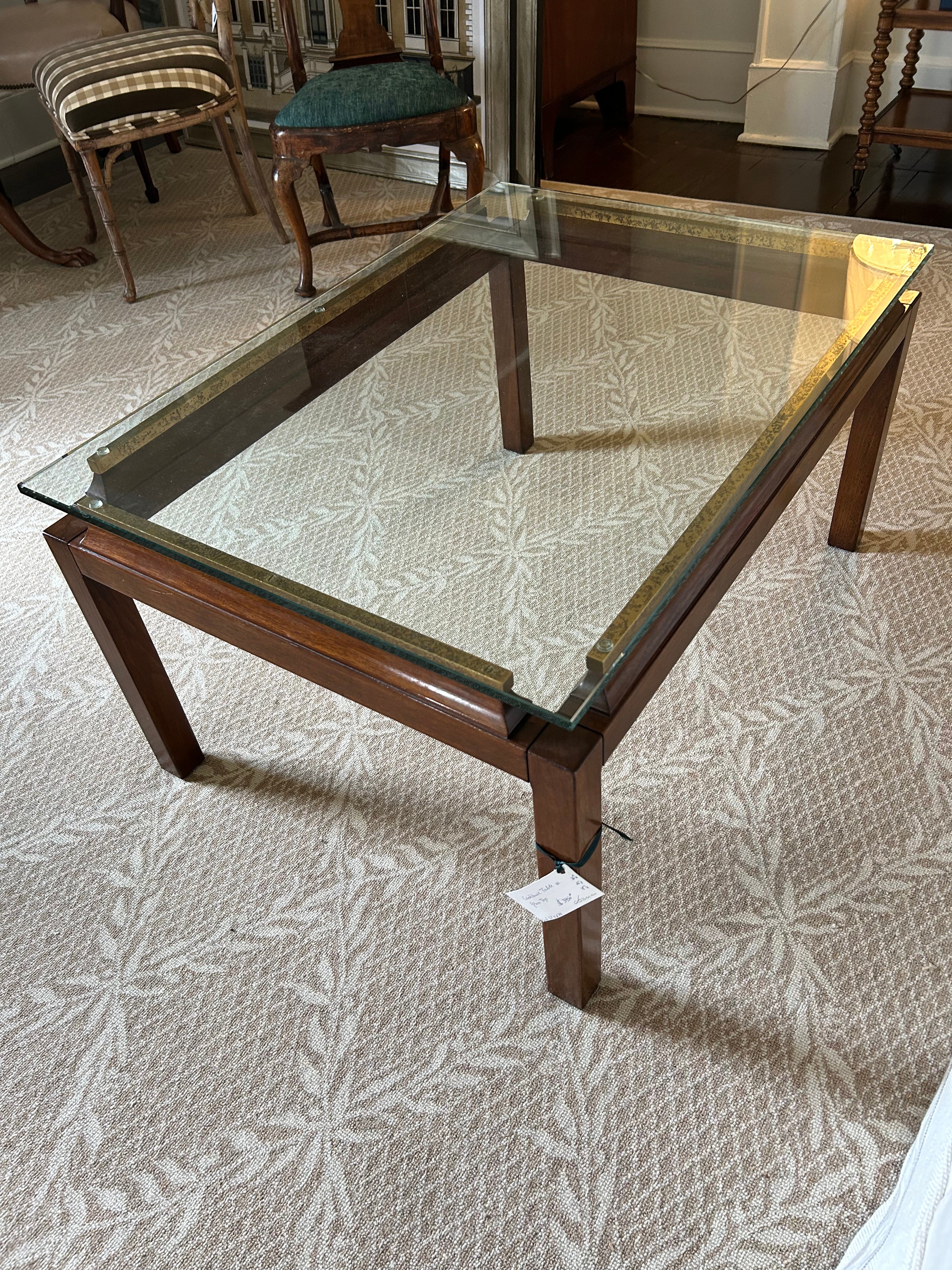 L'association chic du bois foncé, du laiton vieilli et du verre fait de cette table basse transitionnelle une pièce gagnante.  Le verre semble flotter au-dessus de subtiles pièces de laiton vieilli aux belles vis. 