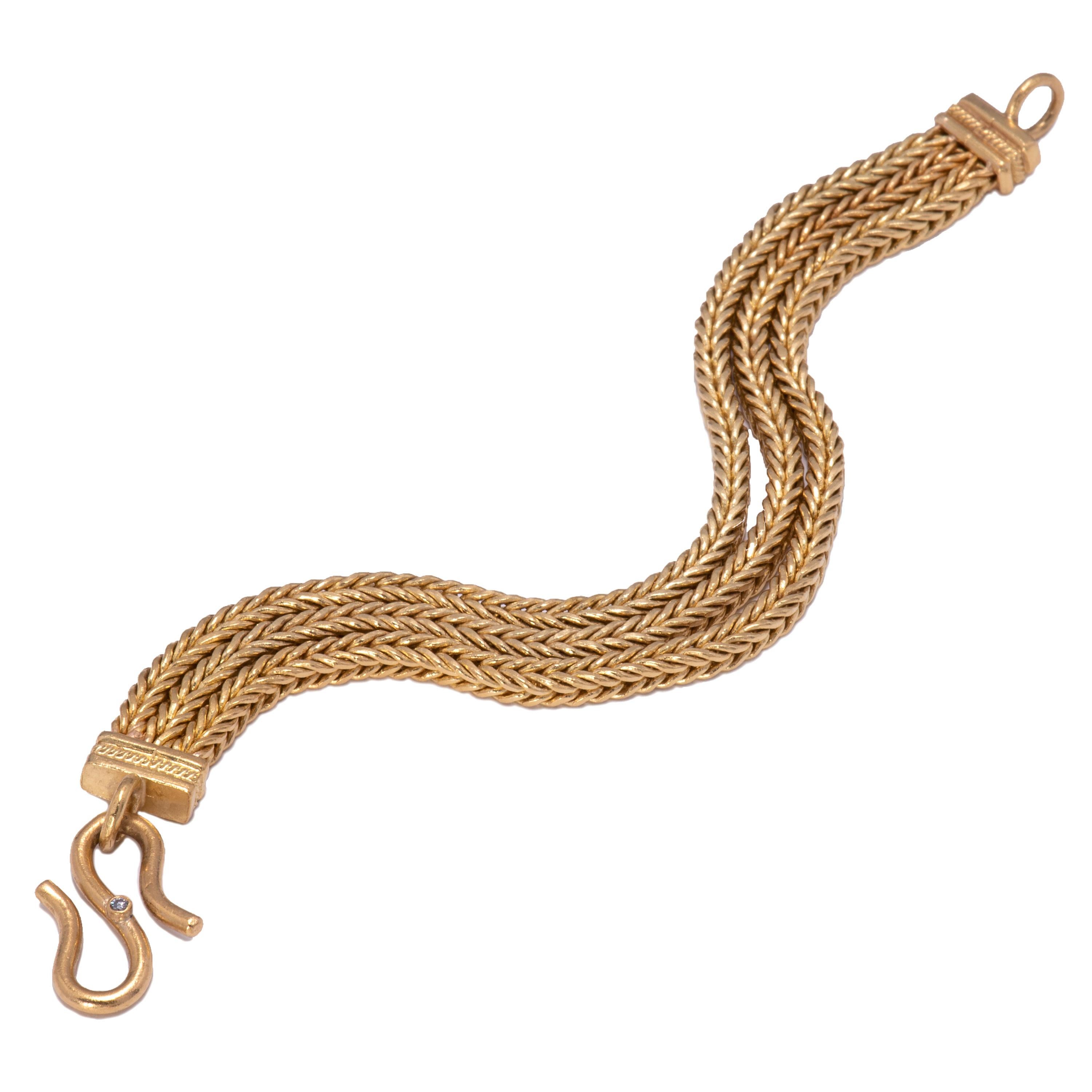 Three lengths of handwoven 22k gold are fused at boxed ends and secure with a hand crafted 22k gold S clasp set with a white diamond. This triple strand bracelet by Keith Berge is 7.25