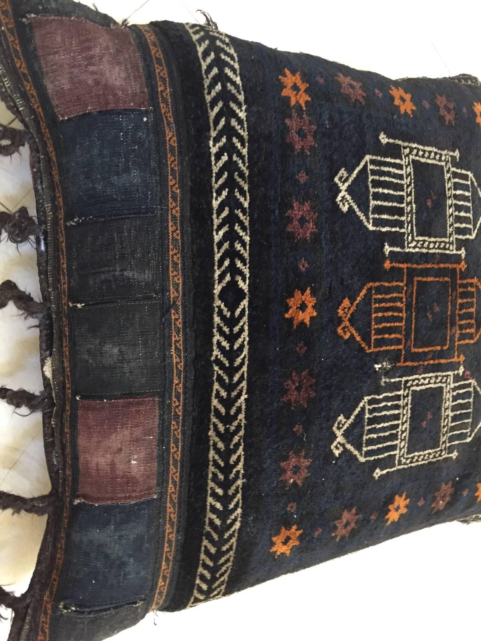 Handmade antique collectible Afghan Baluch camel saddle grain tribal bag,
circa 1880s, this large tribal camel grain bag was filled and made into a large floor pillow.
This tribal textile top rug has beautiful deep blue and black shades with soft