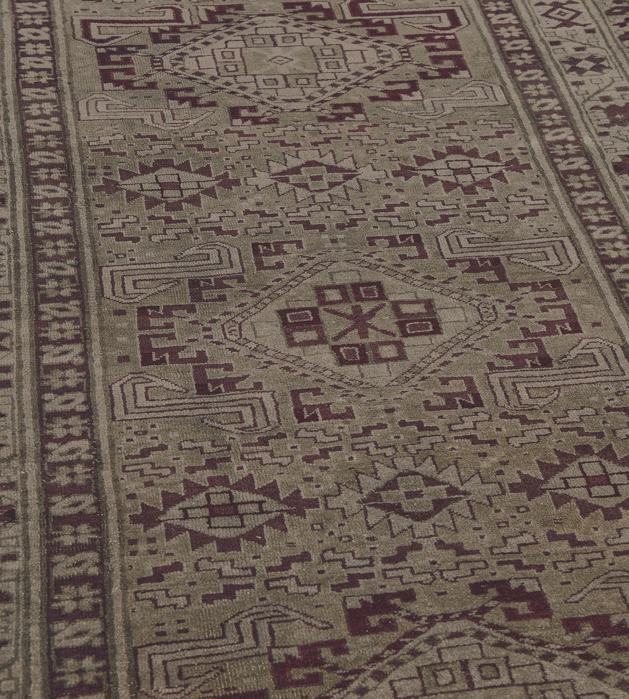Dieser handgewebte antike Läufer aus Agra (um 1900) zeigt ein helles pistaziengrünes Feld, das mit schattierten burgunderroten und elfenbeinfarbenen Stufenrauten und Hakenranken sowie stilisierten Blumenmotiven rund um eine Säule aus fünf