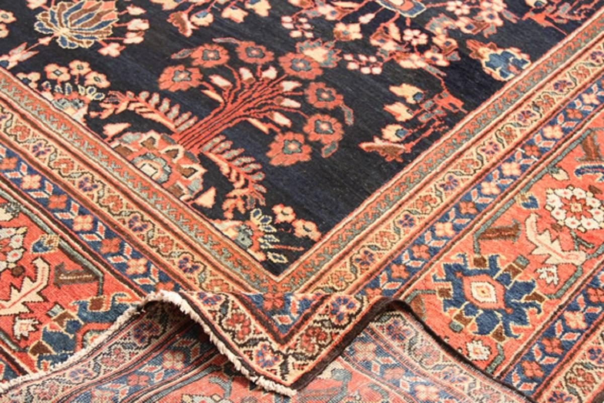 Handwoven antique Persian Mahal rug featuring a bouquet motif on a cobalt blue colored field and orange rust border accented in shades of ivory, light blue, green, gold, coral and brown.  Created from 100% wool by the artisans of Iran, circa 1930.