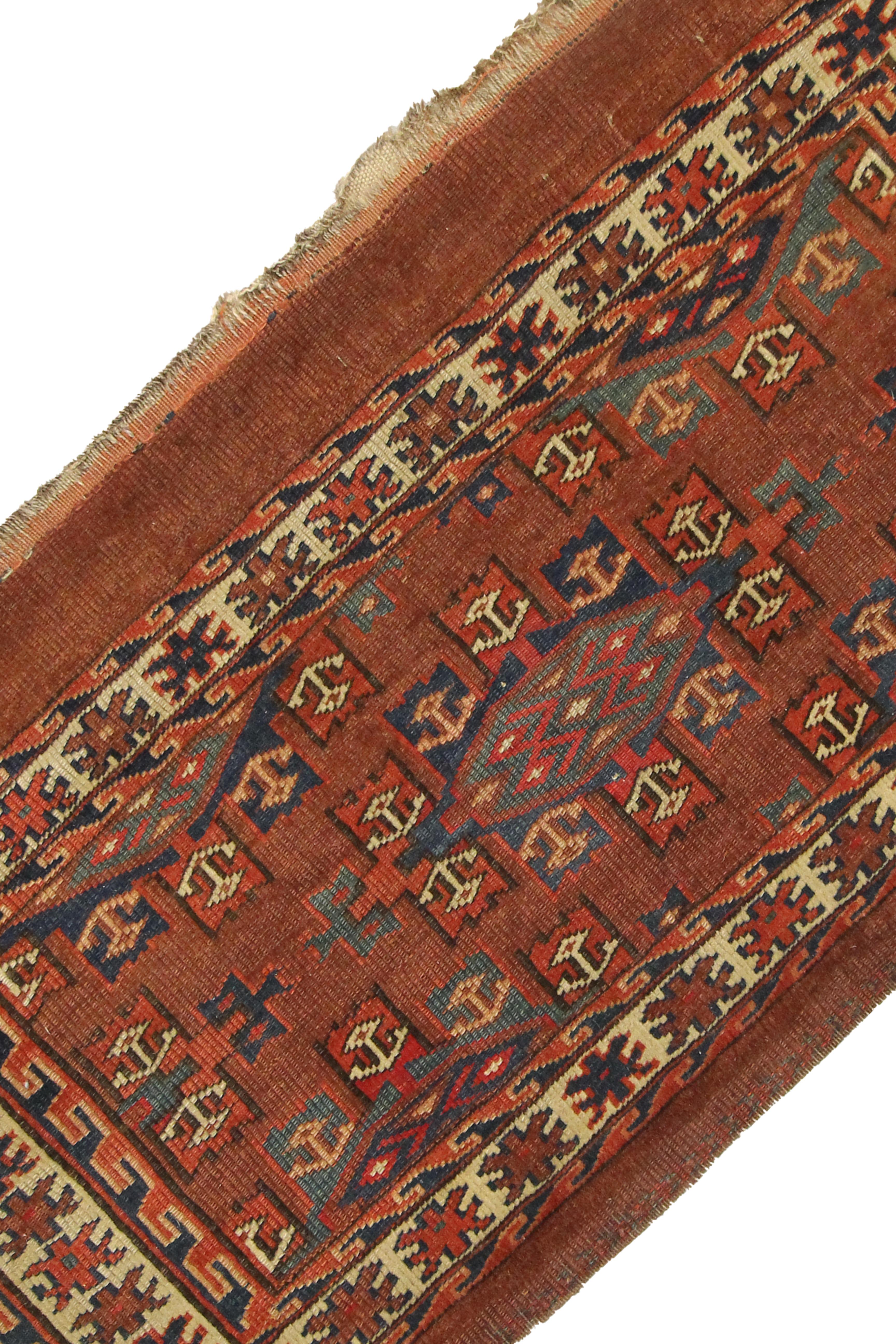This unique Chuval rug is a rare antique rug woven in the 1890s with a traditional Turkmen design. The central pattern is a traditional design woven with geometric patterns in accents of blue, beige and rust on a brown background. The colour palette