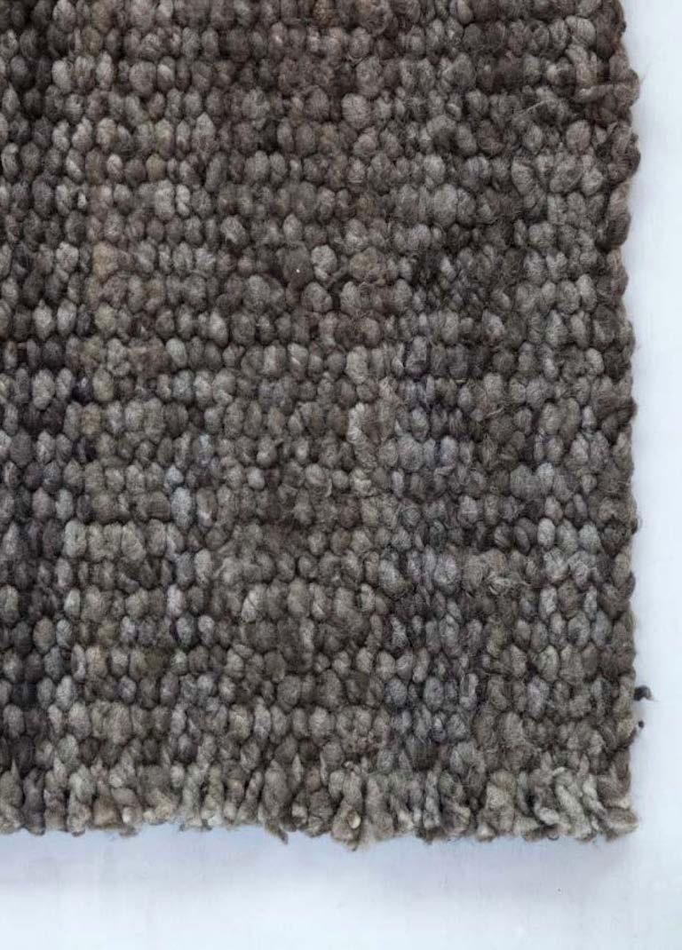 This nubby textured grey color 5'x8' rug is hand woven in the remote area of the Dry Forest of Northern Argentina, using age old methods and created out of pure hand spun sheep wool. It is a unique textile and takes about two months to make.