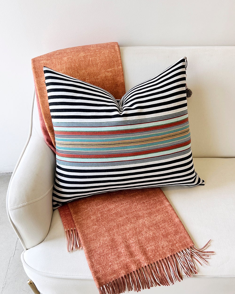 This premium throw pillow is handmade in Mexico using only fair trade and locally sourced materials, bringing the elegance of Latin American style to your home decor. Its bold red, white, black, and green stripes provide a standout addition to any