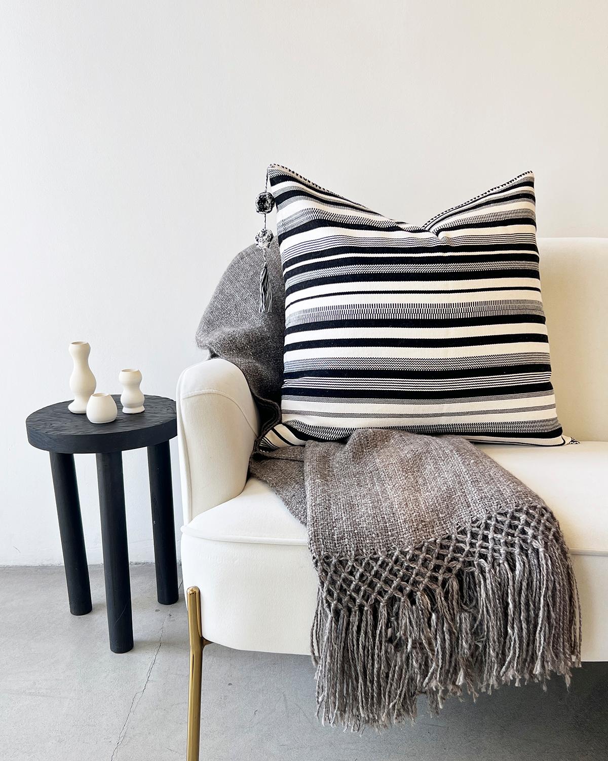 This premium striped throw pillow is crafted from a unique blend of black and white. The contrasting pattern coordinates well with rustic, Latin American decor, bringing a touch of style to any home. Fair trade sourced from local artisans, the