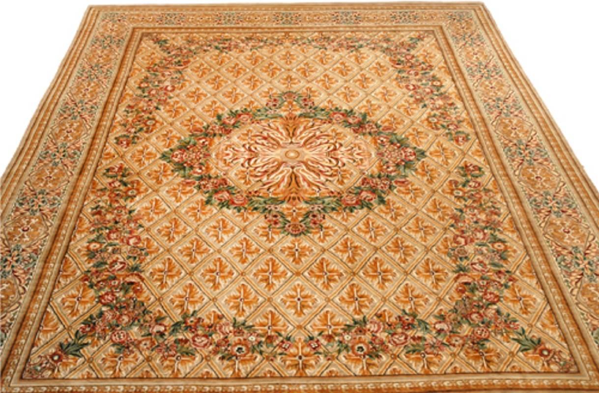 Handwoven Pakistani rug featuring a French Savonnerie design with a gold field and multi-colored border accented in shades of green, blue, amber and burgundy.  Created from 100% wool by the artisans of Pakistan circa 1990.