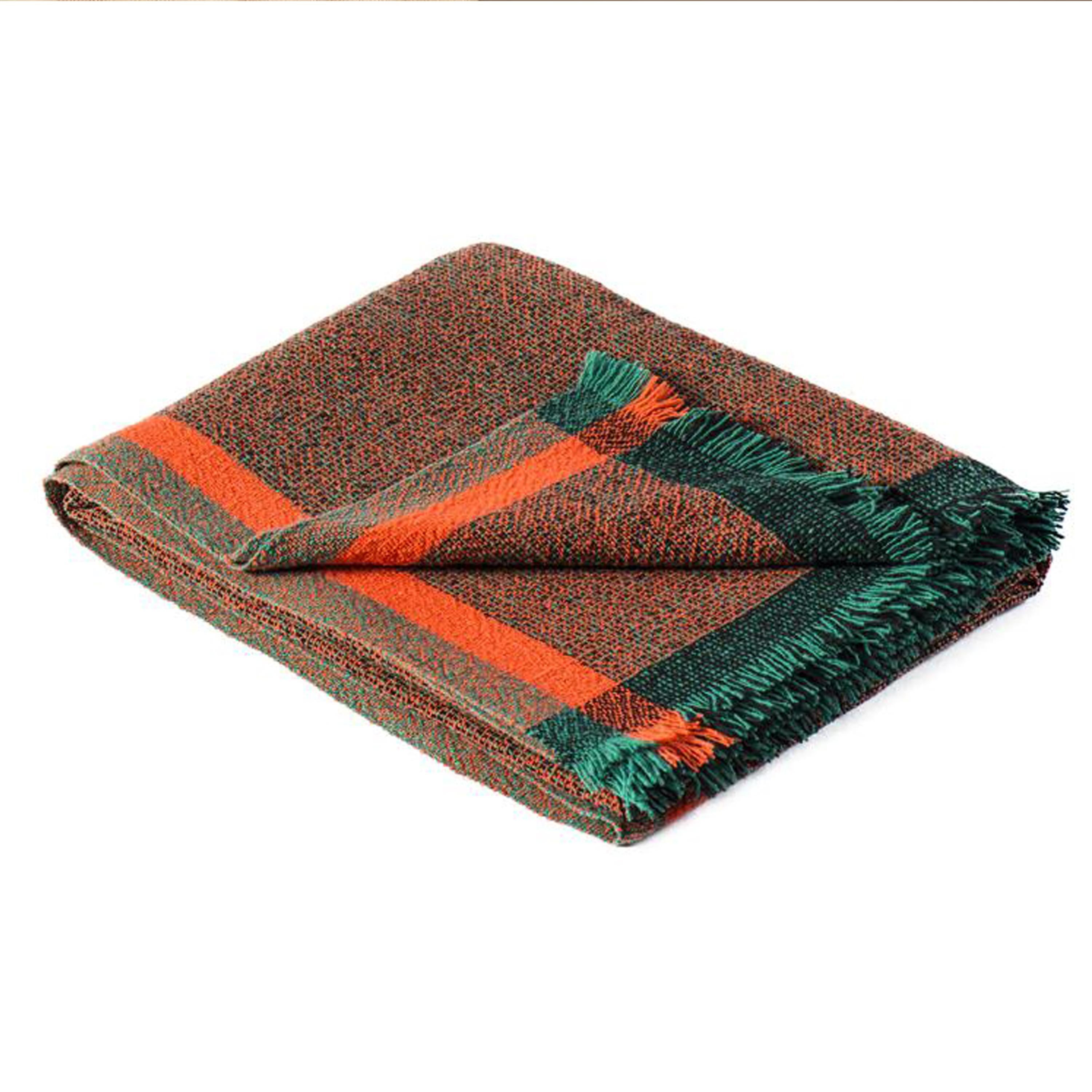 Hand-wove Throw in orange, green, and black, made of 100% eco-friendly french merino wool. Designed by the international designer Cristian Zuzunga. 
The blanket feature two special finishes: a fringed finish and one with intertwined threads. The