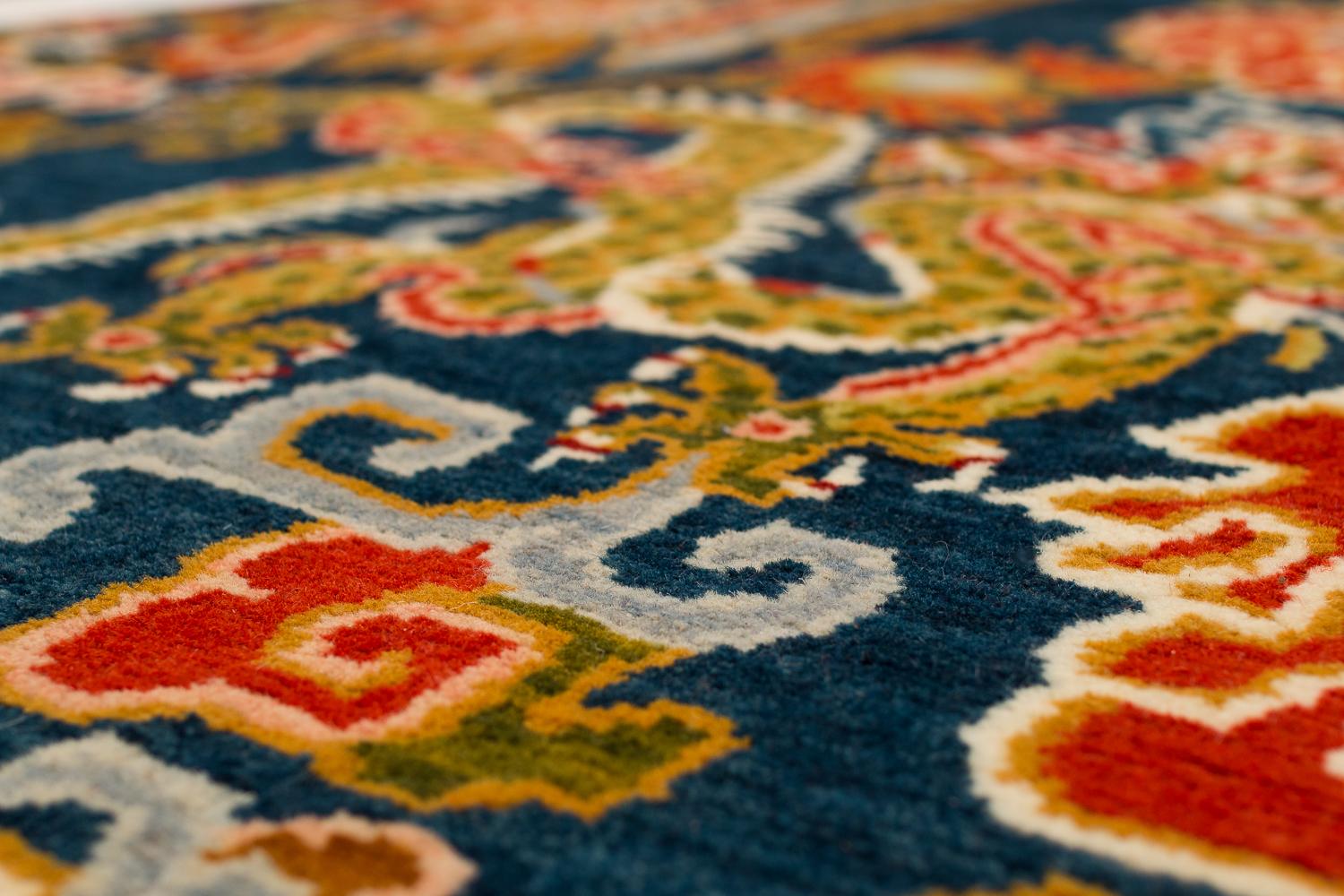 This showstopper carpet is an original design by Joseph Carini and inspired by his deep love for the arts and culture in China. This 3 feet by 6 feet carpet has an oriental motif of dragons and phoenix. The predominant colors are indigo, red and