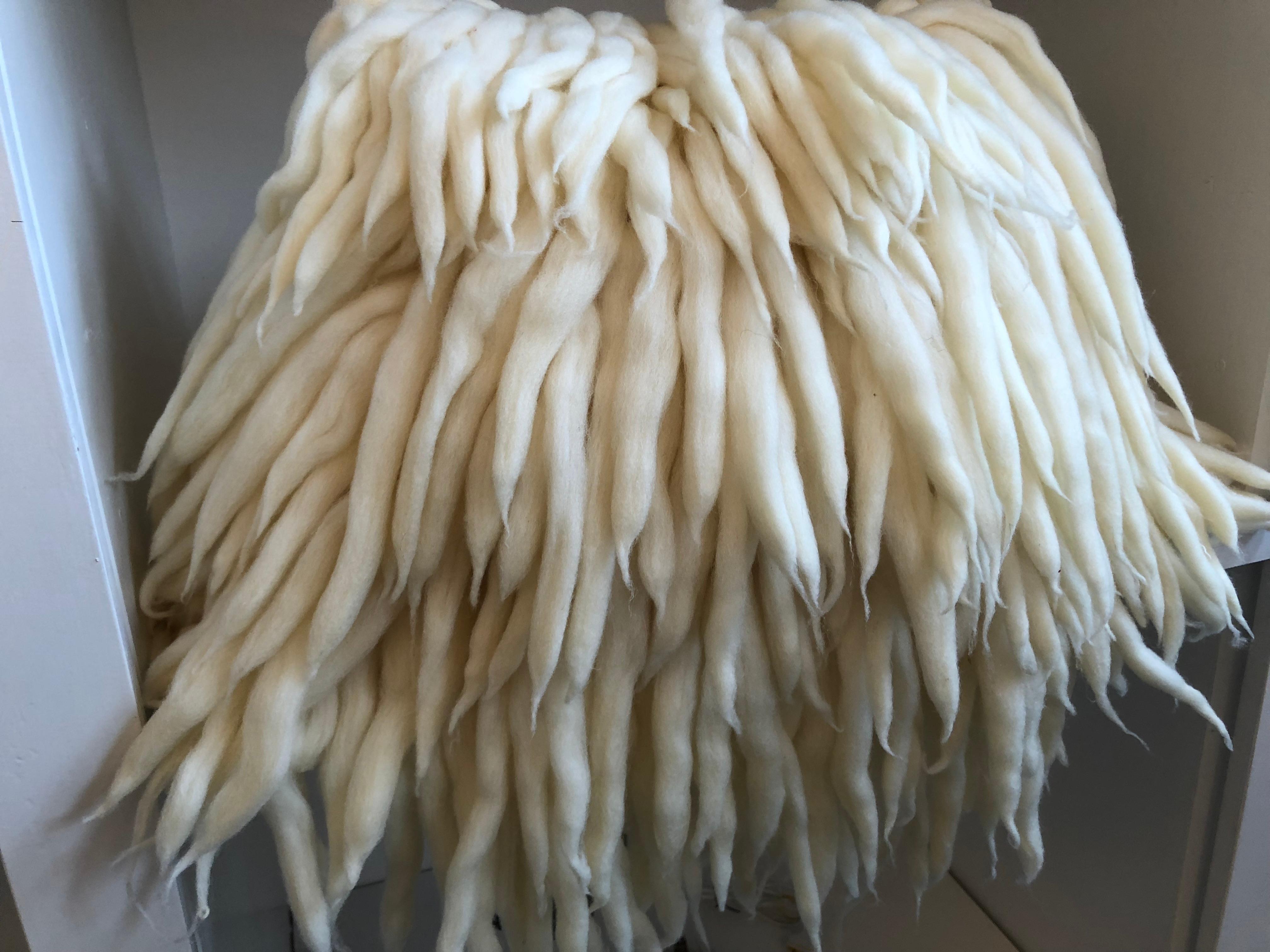 Whimsical handwoven and decorated merino wool pillow with feather and down insert. Made in Italy.